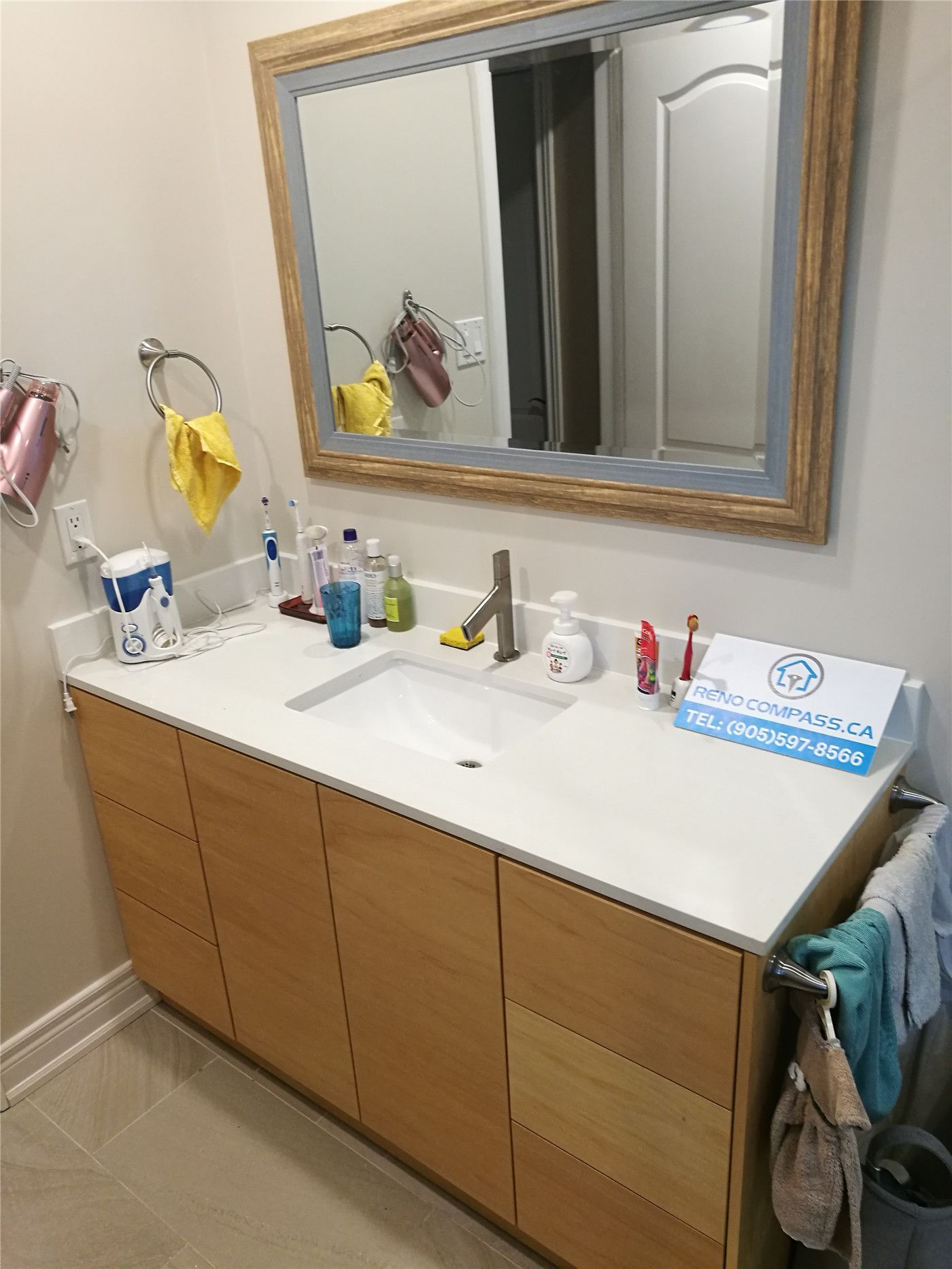 This Richmond Hill bathroom renovation features a modern double-sink vanity with a clean white countertop, natural wood cabinetry, and a large framed mirror to enhance both functionality and style. Updated fixtures, improved storage, and a practical layout create a bright and organized daily-use bathroom space. Completed by an experienced Toronto renovation company, this project highlights quality craftsmanship and contemporary bathroom renovation solutions for homeowners in Richmond Hill and across the GTA.