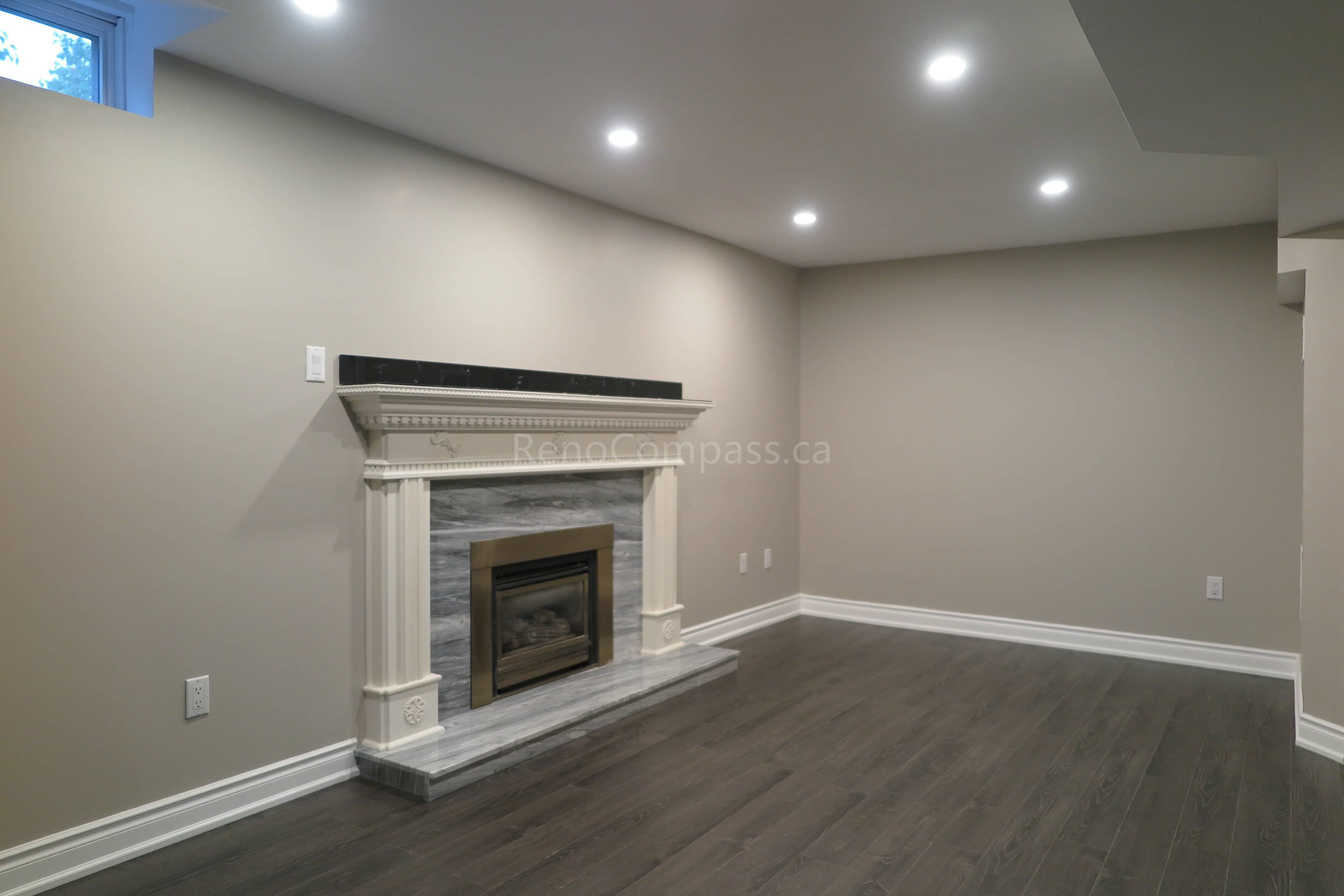 This Markham interior renovation features an open-concept living space with newly installed hardwood flooring, elegant crown molding, and a modern built-in fireplace feature wall. Wide openings between rooms create a spacious and seamless layout, enhanced by recessed lighting and contemporary chandelier fixtures. Completed by Reno Compass, a trusted renovation contractor specializing in full home interior renovations and custom finishing services across Markham and the Greater Toronto Area.