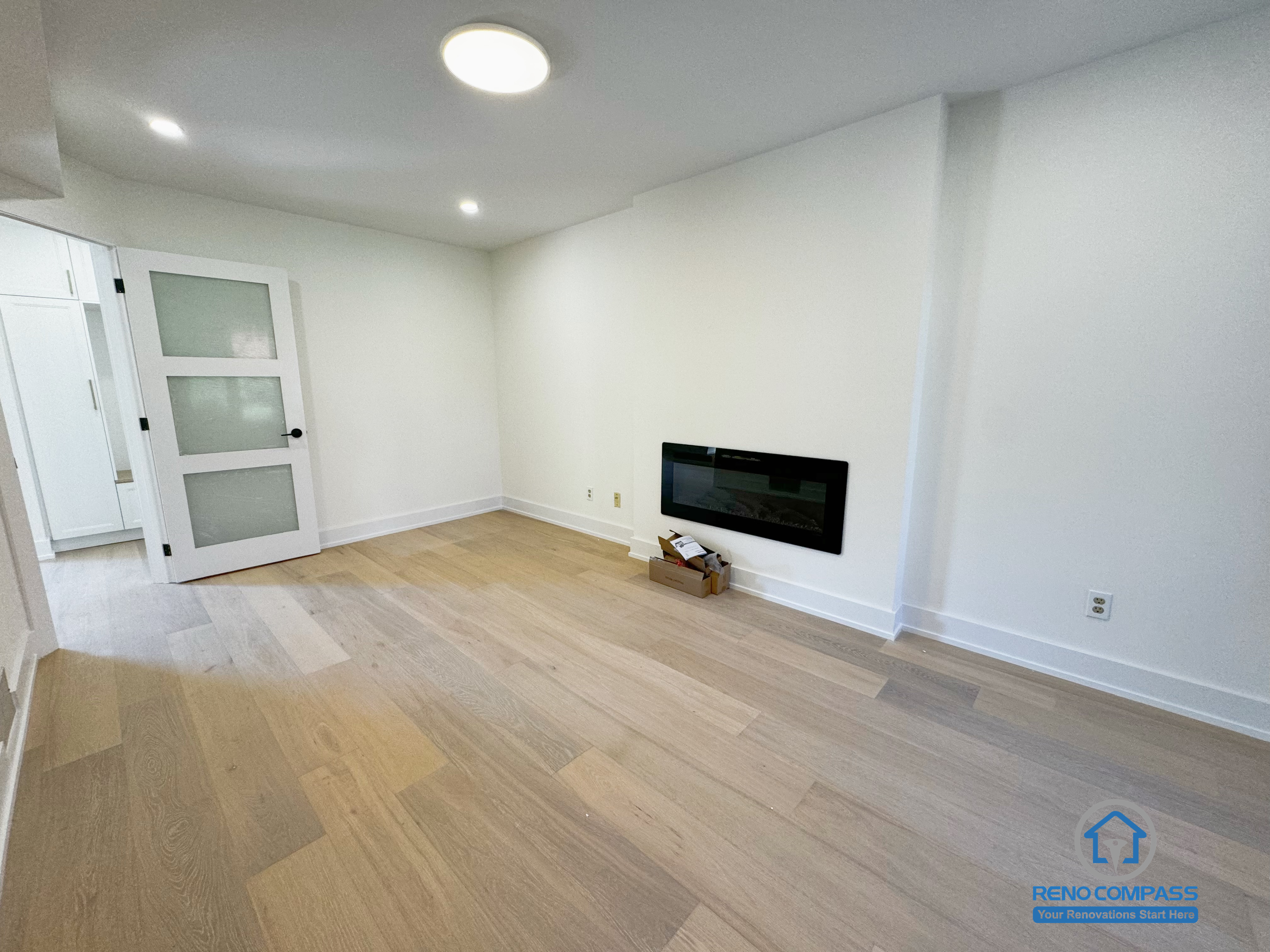 This image shows a completed interior flex room renovation in Richmond Hill, designed with a clean layout and neutral finishes to support flexible daily use. Natural wood flooring, smooth wall finishes, and recessed ceiling lighting create a bright and comfortable interior environment. A wall-mounted fireplace adds visual focus without disrupting floor space, allowing the room to function easily as a media room, home office, or guest space. The overall design prioritizes simplicity, adaptability, and long-term residential comfort.
Location: Richmond Hill · Toronto Contractor: Reno Compass