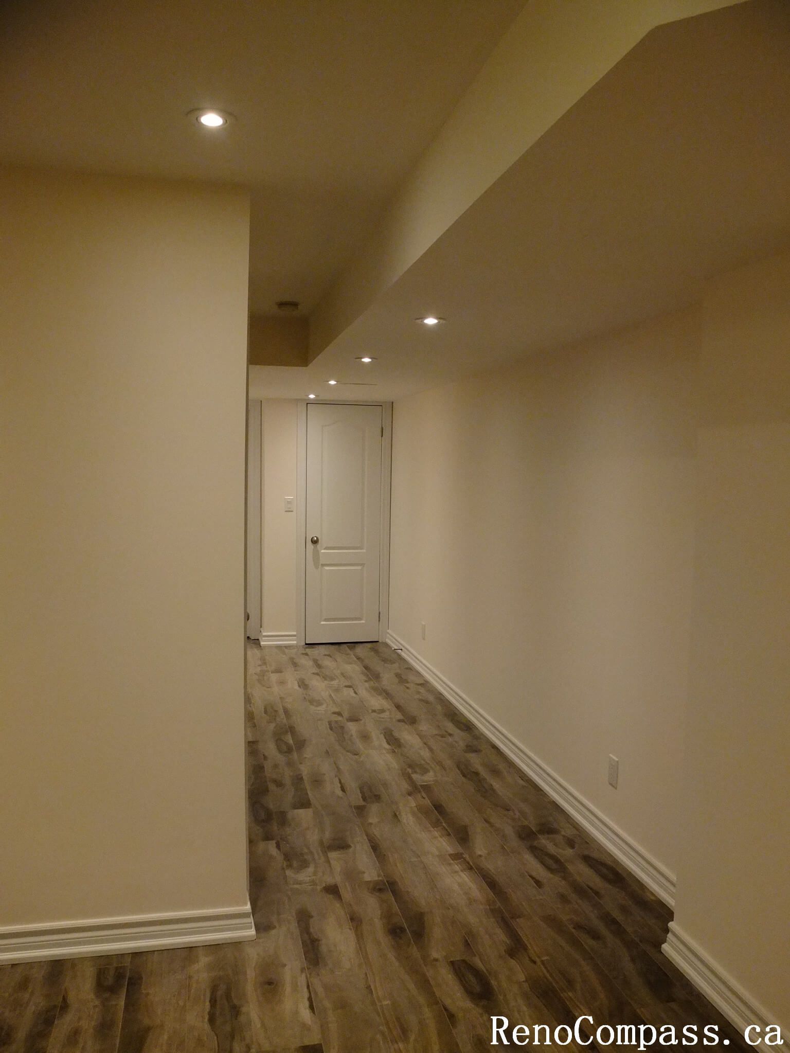 This Markham basement renovation features a clean and modern hallway design with recessed pot lights, durable wood-look vinyl flooring, and neutral wall finishes. The updated layout enhances brightness and flow, creating a functional and inviting basement space for homeowners in Markham.