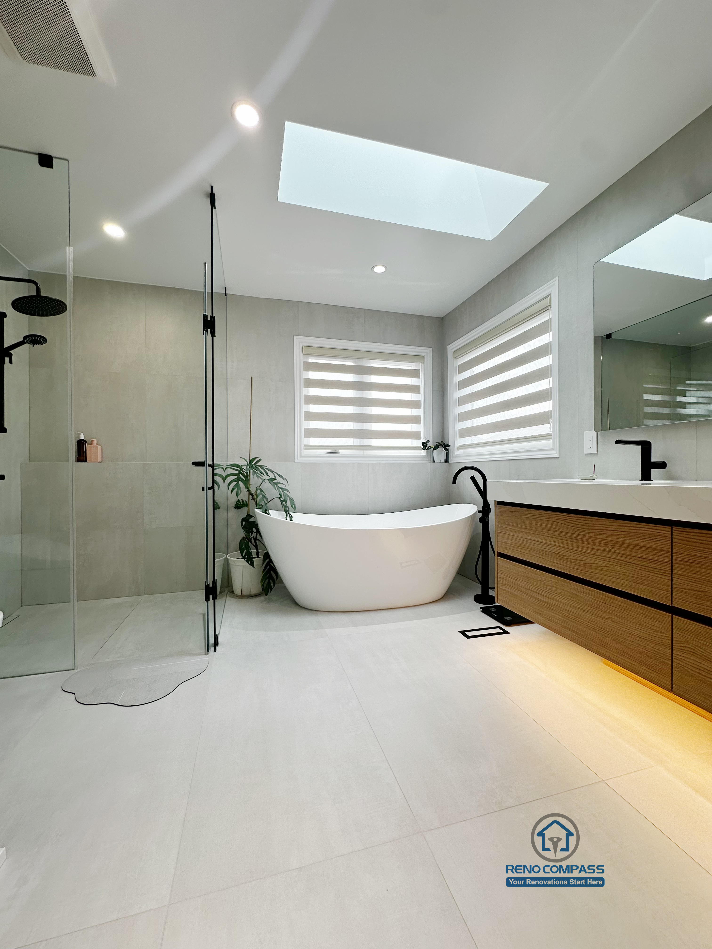 A floor-level view of a curbless bathroom renovation by Reno Compass in Markham, Toronto.
This image highlights the seamless tile flooring, integrated linear drainage, and warm under-vanity lighting that enhance accessibility, safety, and visual continuity.