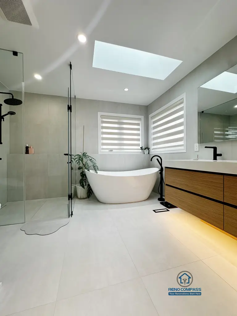 A floor-level view of a curbless bathroom renovation by Reno Compass in Markham, Toronto.
This image highlights the seamless tile flooring, integrated linear drainage, and warm under-vanity lighting that enhance accessibility, safety, and visual continuity.