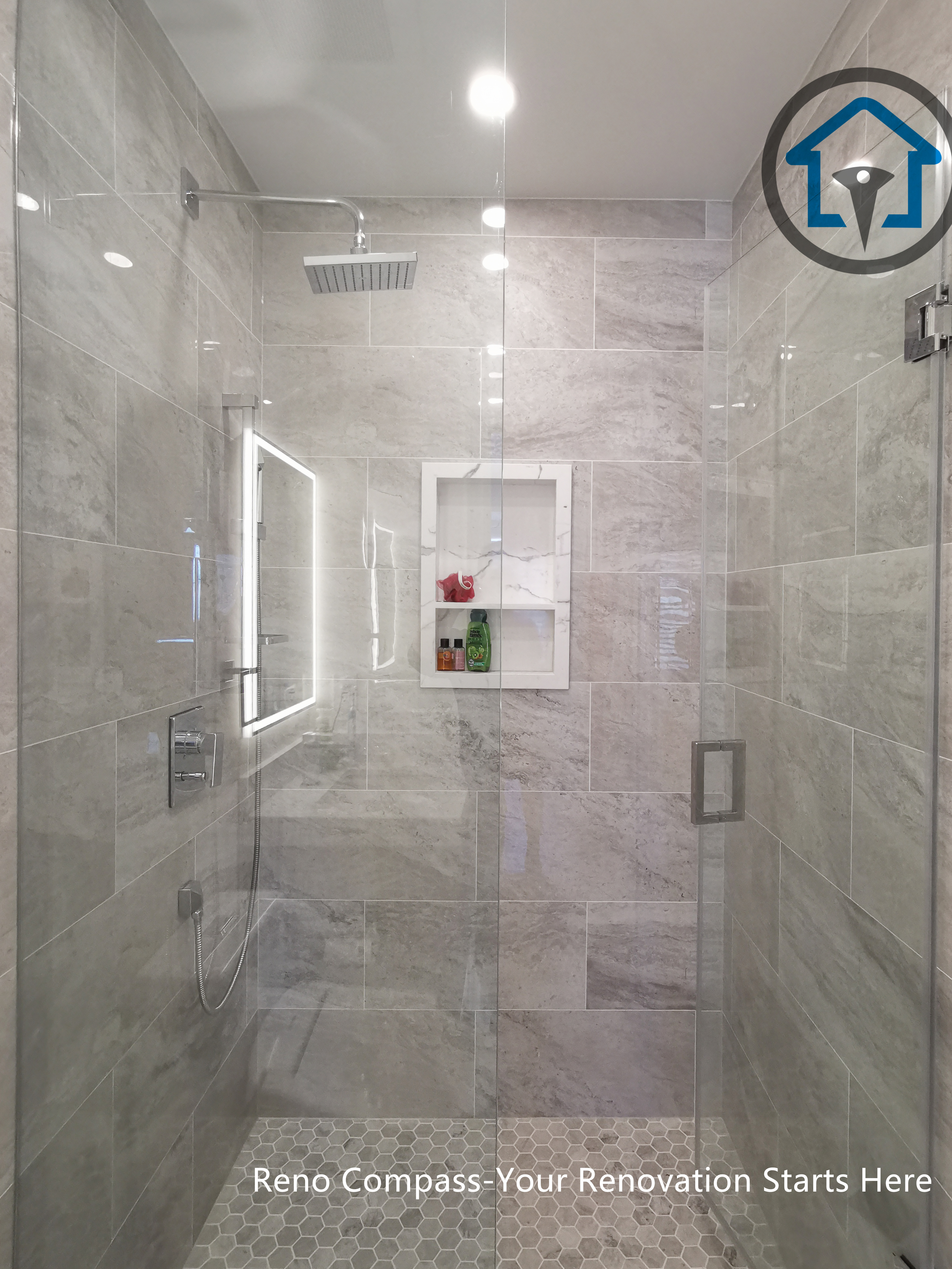 This North York bathroom renovation features a modern floating-style vanity paired with a quartz countertop and a glass-enclosed shower. Neutral wall tiles, built-in shower storage, and LED mirror lighting create a clean and functional layout that maximizes space and comfort. Completed by a Toronto renovation company focused on efficient bathroom design and quality craftsmanship.