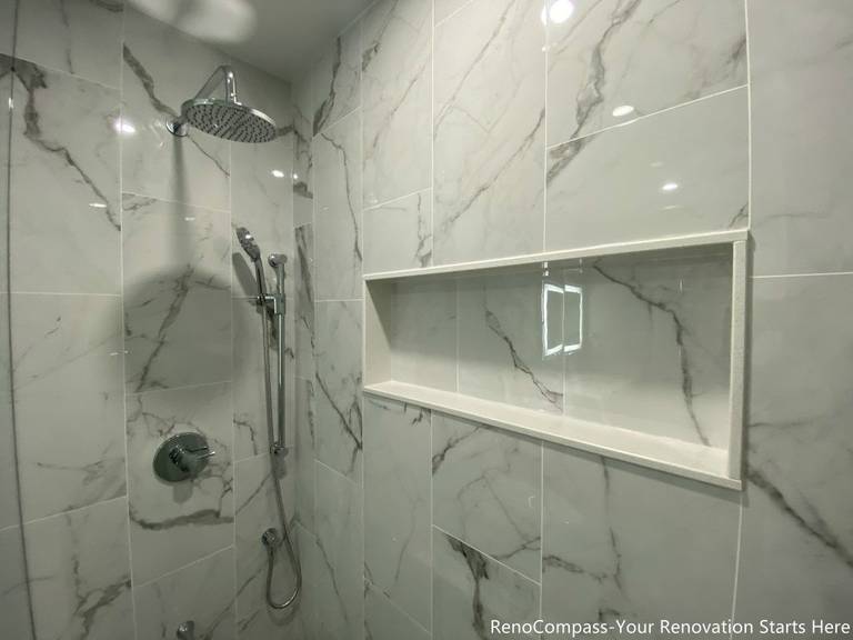 This Oakville bathroom renovation features a modern walk-in shower with large-format marble-look tiles, a built-in recessed shower niche, and a sleek rainfall shower system. The clean tile layout and contemporary fixtures create a bright, spa-inspired shower space that combines style with practicality. Completed by a trusted Toronto renovation company, this upgrade focuses on waterproofing quality, durable materials, and functional storage solutions to deliver a modern bathroom designed for comfort and long-term performance.