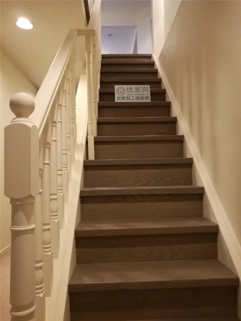 This image highlights a completed staircase flooring renovation in North York, featuring hardwood stair treads paired with classic white railings and balusters. The dark wood finish on the stairs creates strong visual contrast while maintaining a warm and timeless interior aesthetic. Precise stair installation improves safety, durability, and overall visual continuity between levels. This North York flooring renovation demonstrates skilled craftsmanship and careful detailing, delivered by a professional Toronto renovation company specializing in flooring and staircase upgrades.