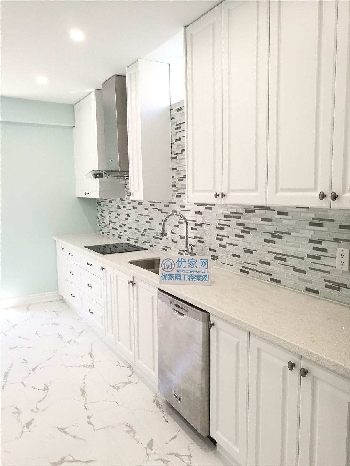 This Vaughan basement kitchen renovation features elegant white cabinetry, a contemporary mosaic backsplash, and glossy marble-look tile flooring for a bright and upscale finish. Stainless steel appliances and recessed lighting enhance functionality and style. Completed by a professional Toronto renovation company, this kitchen upgrade creates a modern, durable, and inviting space ideal for rental suites or family use.