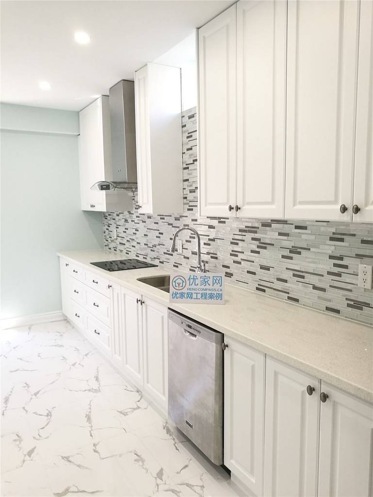 This Vaughan basement kitchen renovation features elegant white cabinetry, a contemporary mosaic backsplash, and glossy marble-look tile flooring for a bright and upscale finish. Stainless steel appliances and recessed lighting enhance functionality and style. Completed by a professional Toronto renovation company, this kitchen upgrade creates a modern, durable, and inviting space ideal for rental suites or family use.