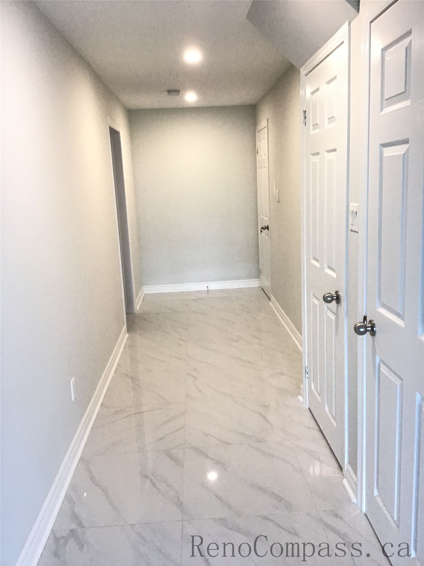 This Whitby basement renovation showcases a clean and contemporary hallway design featuring recessed LED pot lights, smooth neutral-tone walls, and large-format marble-look porcelain tiles. The bright lighting and reflective flooring enhance the sense of space, while crisp white doors and trim create a polished, modern basement finish that blends functionality with refined style.

Upload the next image and I’ll continue organizing them in the same SEO format.