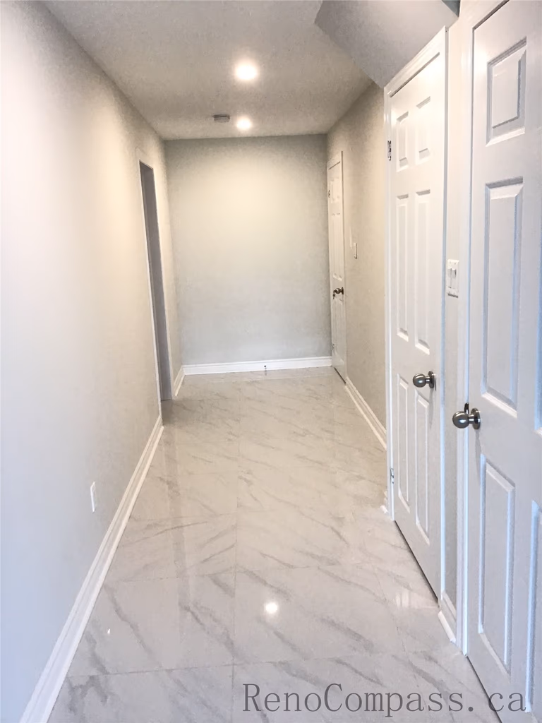 This Whitby basement renovation showcases a clean and contemporary hallway design featuring recessed LED pot lights, smooth neutral-tone walls, and large-format marble-look porcelain tiles. The bright lighting and reflective flooring enhance the sense of space, while crisp white doors and trim create a polished, modern basement finish that blends functionality with refined style.

Upload the next image and I’ll continue organizing them in the same SEO format.