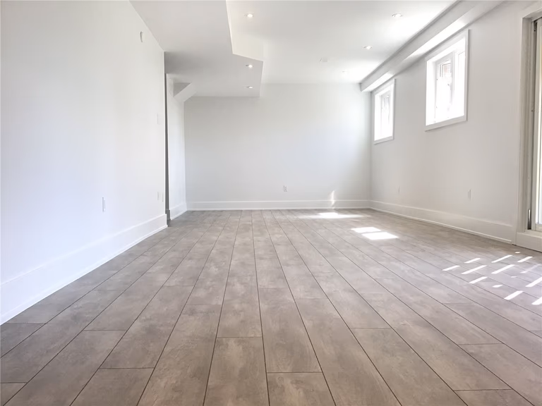 This Markham full home renovation features a spacious and fully finished basement with modern vinyl plank flooring, recessed lighting, and large windows for natural light. The open layout provides flexible space for entertainment, home office, or additional living areas. Completed by a trusted Toronto Renovation Company, this basement design enhances both usability and property value.