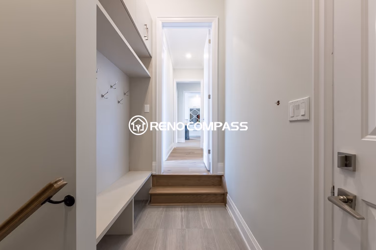 Custom mudroom and walk-in closet renovation in Newmarket featuring built-in bench seating, wall hooks and storage shelving. Designed and completed by a professional Toronto renovation company, this functional entry space helps keep the home organized while adding a clean modern look.