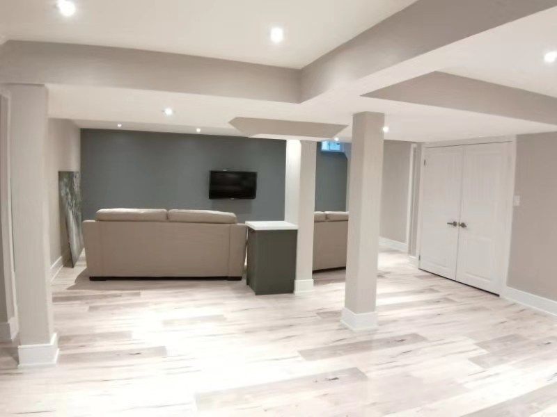 This Richmond Hill interior partial renovation showcases a modern basement living and entertainment space featuring upgraded flooring, recessed lighting, and a contemporary accent wall with mounted TV setup. The redesigned layout creates a comfortable and stylish area for family gatherings, movie nights, and everyday relaxation. Neutral tones and high-quality finishes enhance brightness and visual depth, adding both functionality and value to the home. Completed by Reno Compass, this interior remodeling project highlights professional basement renovation services across Richmond Hill and the Greater Toronto Area.