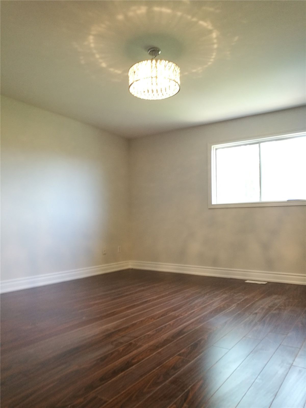 This Mississauga large-scale interior renovation features a refreshed bedroom space designed with warmth and subtle elegance. The newly installed hardwood flooring brings depth and texture, while the crystal chandelier adds a refined focal point that elevates the room’s ambiance.

Clean wall finishes, upgraded baseboards, and balanced natural light from the window create a calm and inviting environment. As part of a comprehensive home remodeling project in Mississauga, this renovation demonstrates attention to lighting design, flooring craftsmanship, and cohesive interior finishing throughout the property.