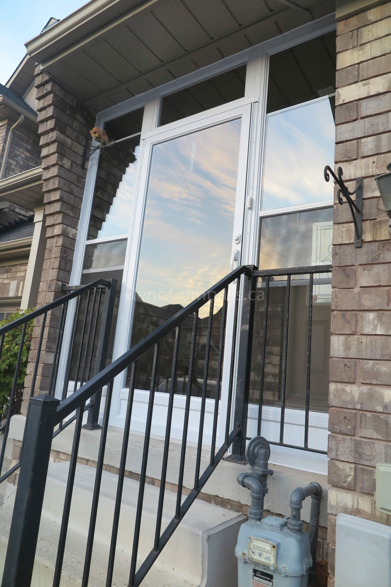 After photo of a Markham home storm door installation project by Reno Compass Inc. Featuring a modern aluminum-framed storm door with clear glass panels and black railing, this upgrade improves both safety and energy efficiency while keeping the exterior stylish and durable.