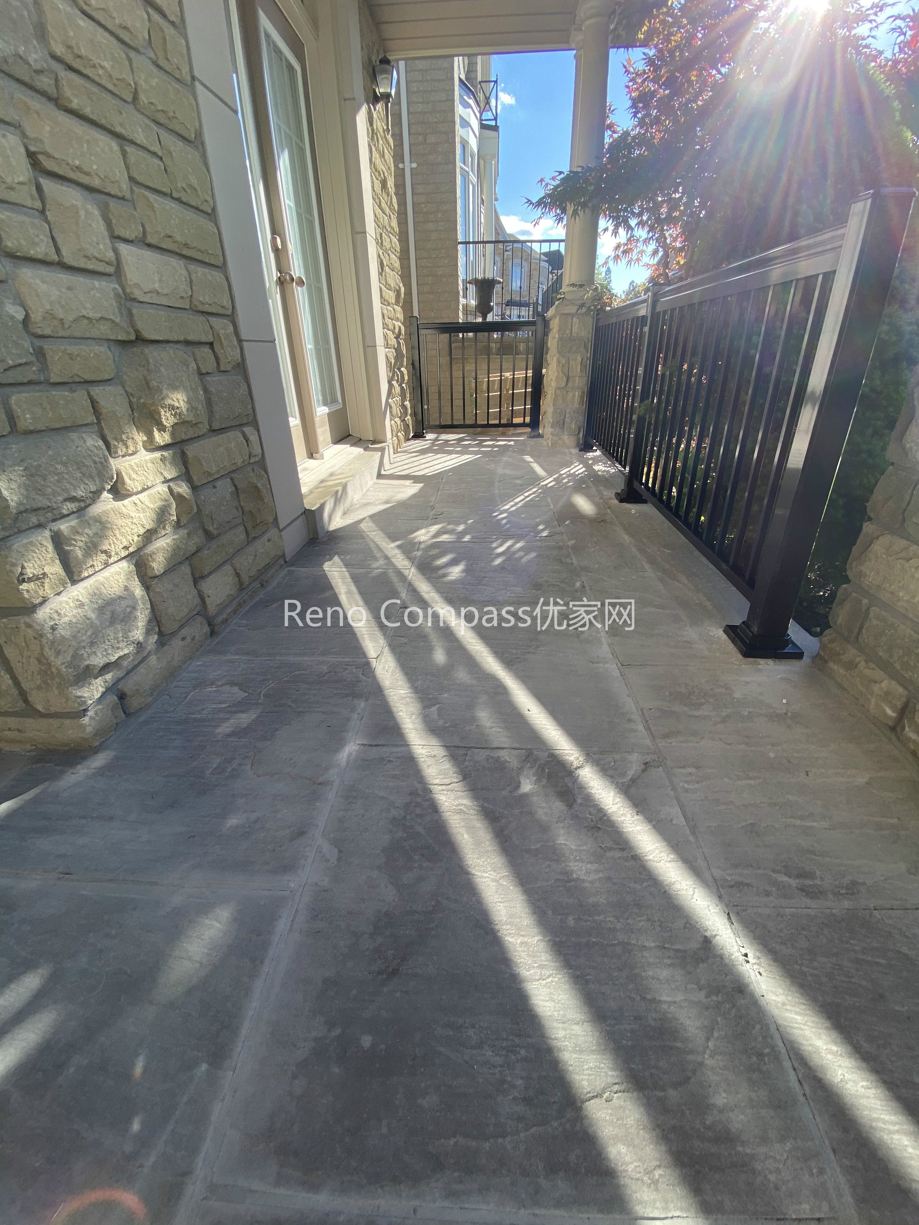 This image features a natural stone interlocking walkway along the side entrance of a North York home. The stone pavers are precisely installed to create a smooth, level walking surface that integrates seamlessly with the home’s stone exterior and metal railing. Proper spacing, alignment, and surface preparation ensure durability, drainage performance, and safe year-round use. Designed as part of a complete driveway interlocking project, this walkway enhances accessibility while maintaining a cohesive outdoor design. Completed by a Toronto interlocking and landscaping contractor, the project demonstrates careful craftsmanship and attention to functional detailing.