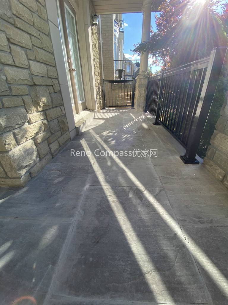 This image features a natural stone interlocking walkway along the side entrance of a North York home. The stone pavers are precisely installed to create a smooth, level walking surface that integrates seamlessly with the home’s stone exterior and metal railing. Proper spacing, alignment, and surface preparation ensure durability, drainage performance, and safe year-round use. Designed as part of a complete driveway interlocking project, this walkway enhances accessibility while maintaining a cohesive outdoor design. Completed by a Toronto interlocking and landscaping contractor, the project demonstrates careful craftsmanship and attention to functional detailing.