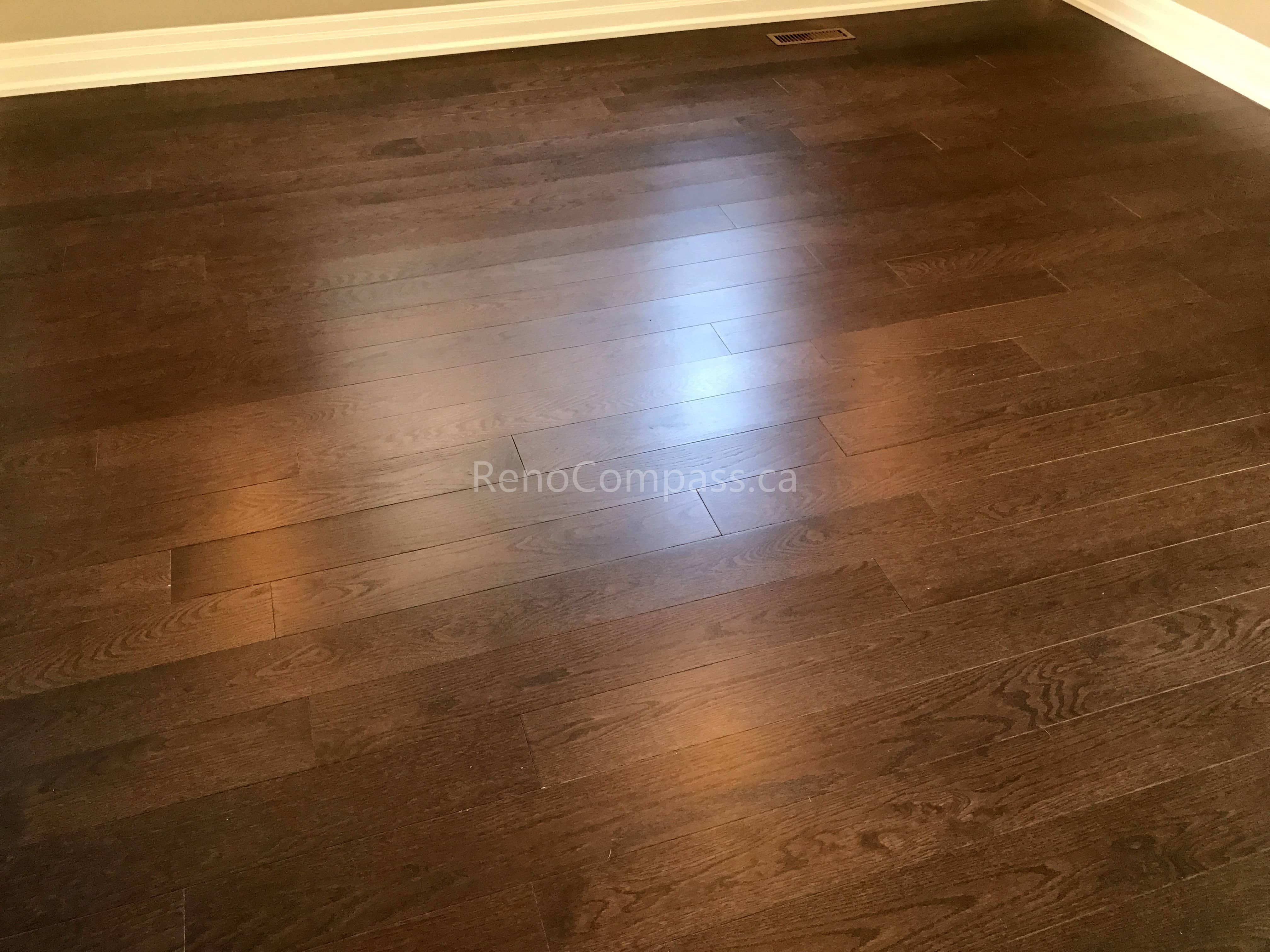 This Markham flooring renovation showcases newly installed dark hardwood flooring with a smooth, polished finish that enhances the warmth and elegance of the living space. The rich wood tones create depth and contrast while maintaining a modern and timeless interior style. Completed by a professional Toronto renovation company, the installation ensures precise plank alignment, durable materials, and a seamless flooring upgrade designed for long-term residential use.
