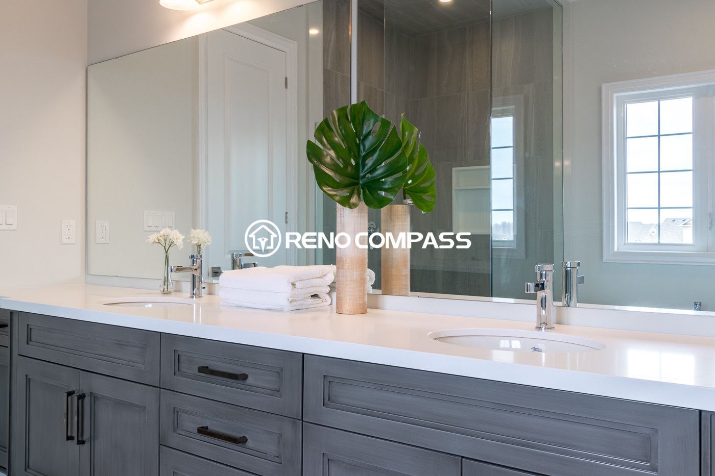 Modern bathroom renovation in Newmarket featuring a double sink vanity, quartz countertop, large wall mirror and elegant cabinetry. Completed by a professional Toronto renovation company, this design combines functionality and clean contemporary style for everyday comfort.