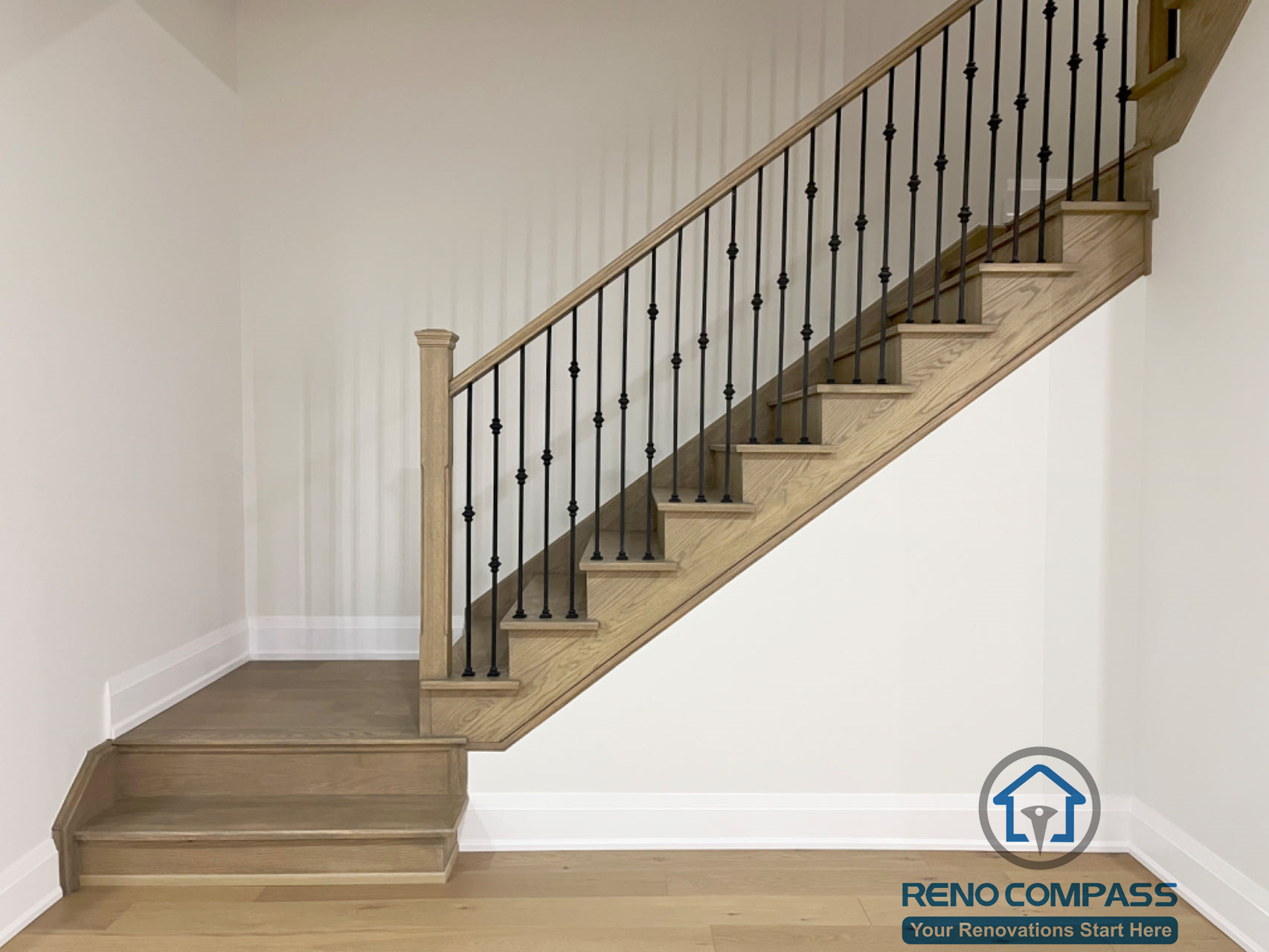 Basement staircase renovation in Newmarket featuring custom wood stair treads, black iron balusters, and a clean modern railing design that connects the basement seamlessly to the main floor.