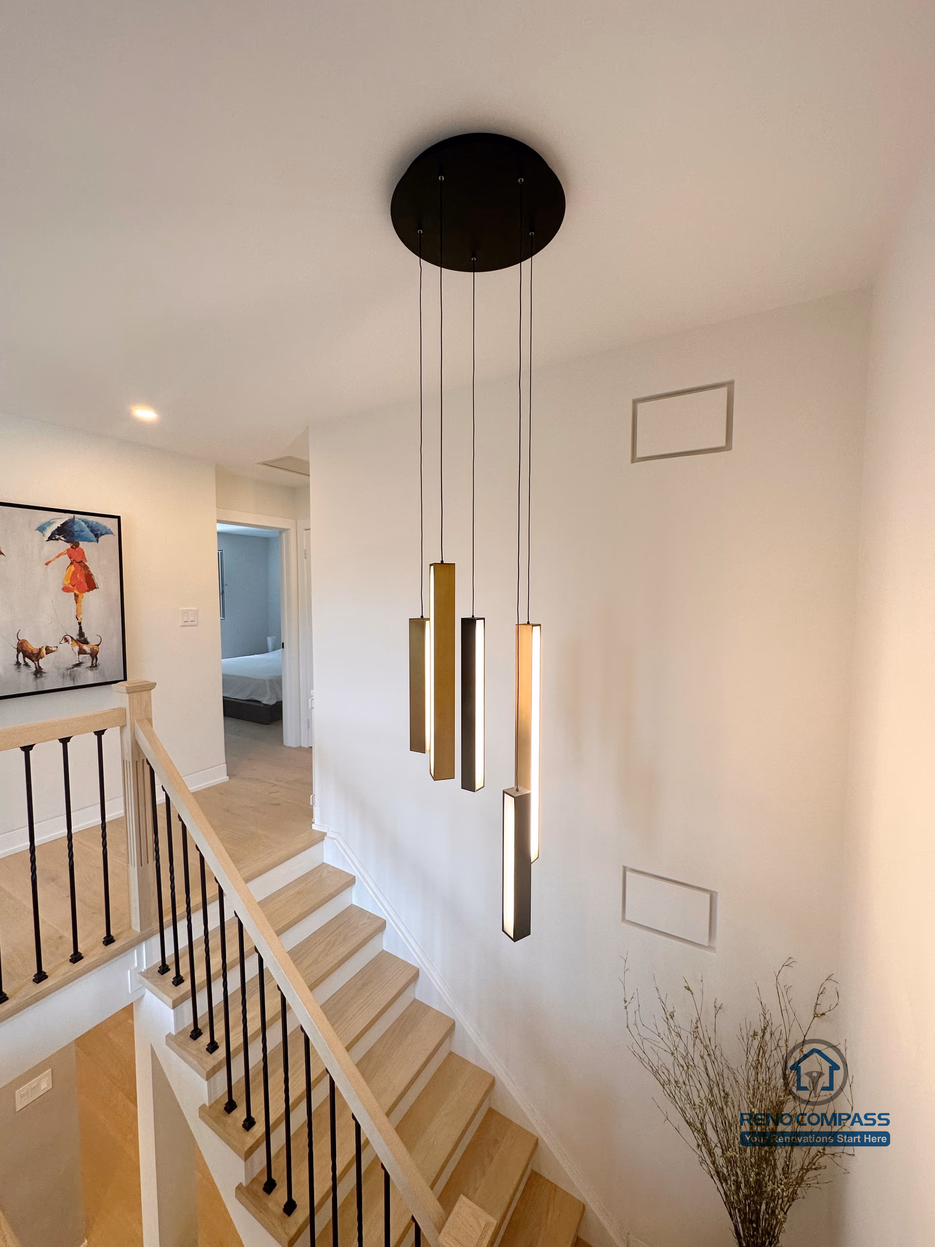 This Toronto stair renovation features custom hardwood steps, black metal railings, and modern pendant lighting that enhances vertical space and architectural depth. The seamless integration of stair design and flooring creates a bright, cohesive interior, showcasing refined craftsmanship ideal for contemporary Toronto home renovations.