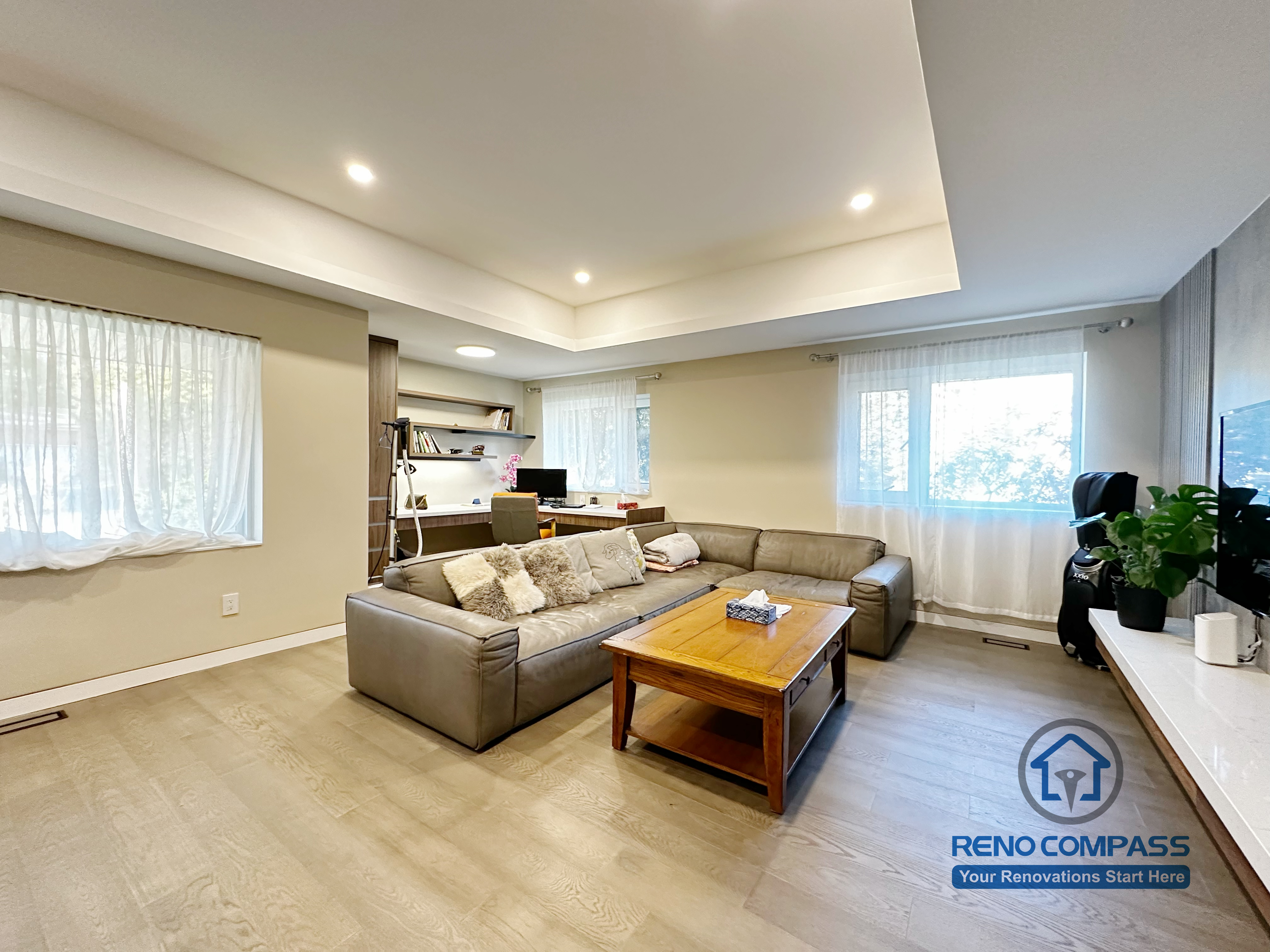 Open-concept living room completed as part of a North York interior renovation. This view highlights the seamless connection between the living area and adjacent spaces, featuring recessed ceiling lighting, wide-plank flooring, and a custom TV wall that anchors the room. Designed for clarity, flow, and everyday comfort by a professional Toronto renovation company.
