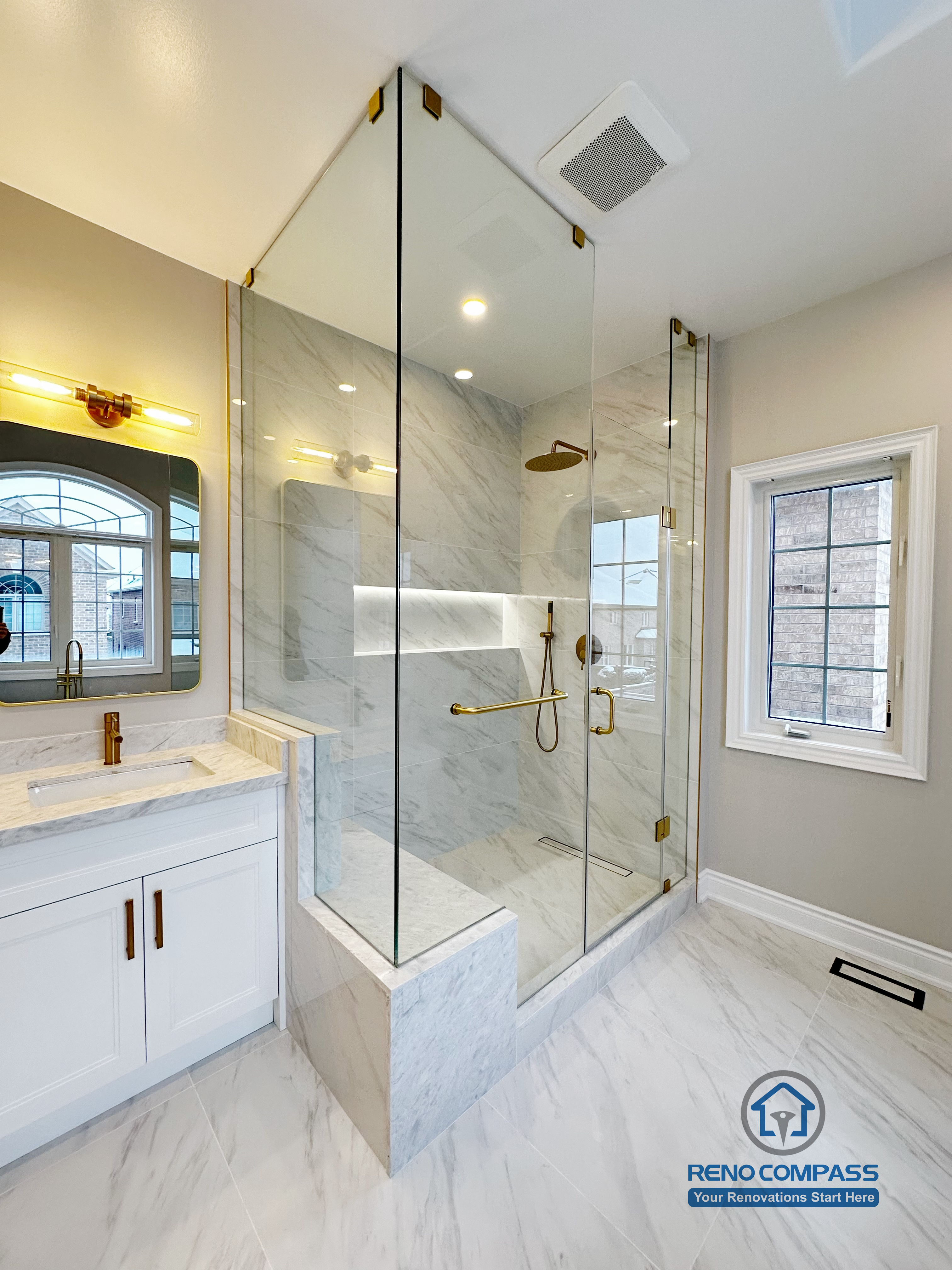 Full view of a Vaughan primary bathroom renovation showcasing a custom double vanity with quartz countertop, gold fixtures, LED mirror lighting, and a frameless glass walk-in shower finished with marble-look porcelain tile. The layout maximizes light, storage, and circulation, completed by a professional Toronto renovation company specializing in high-end bathroom design.