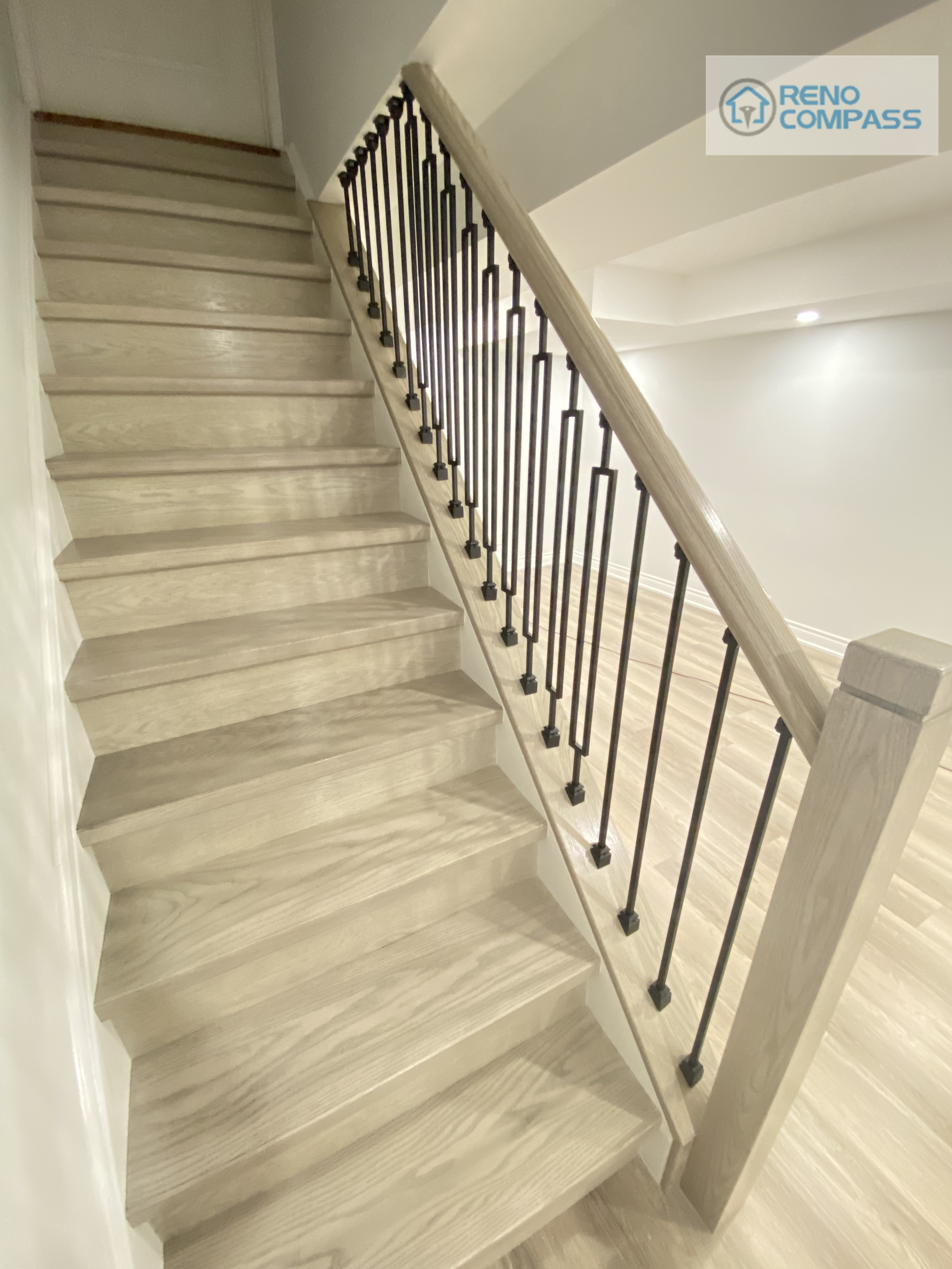 This Woodbridge basement staircase renovation features durable wood-look steps paired with sleek black metal railings, improving both safety and visual continuity. The updated staircase integrates seamlessly with the basement flooring and open layout, creating a clean and cohesive transition between levels.