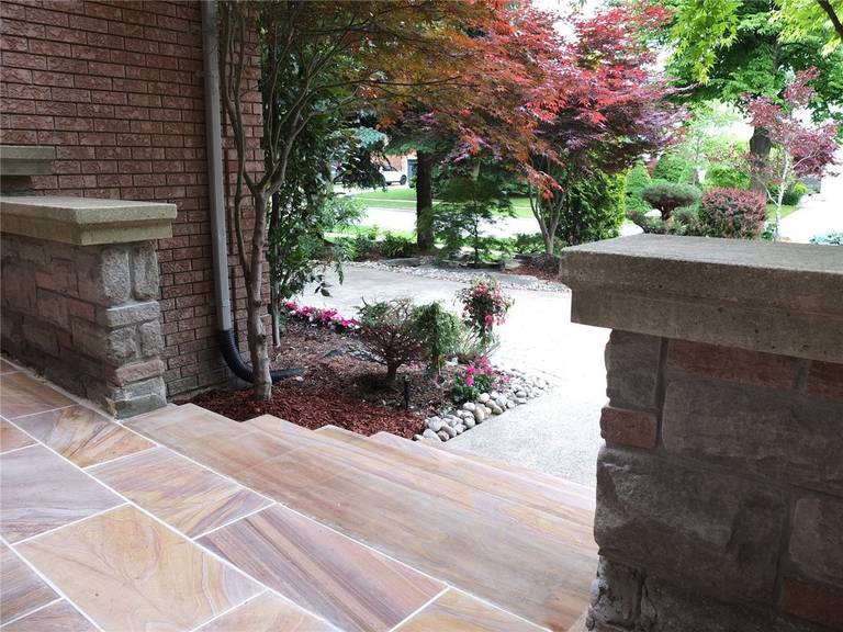 This Richmond Hill front yard landscaping renovation highlights a beautifully upgraded home entrance with custom natural stone steps, structured garden beds, and decorative front yard planting. The project features professionally installed stone stair treads, refreshed mulch landscaping, and carefully arranged greenery that enhances curb appeal and creates a welcoming pathway to the main entrance. Designed with durability and aesthetics in mind, the renovation improves both accessibility and visual harmony with the home’s exterior. Completed with expert craftsmanship, this front yard upgrade delivers a clean, elegant, and low-maintenance landscaping solution.