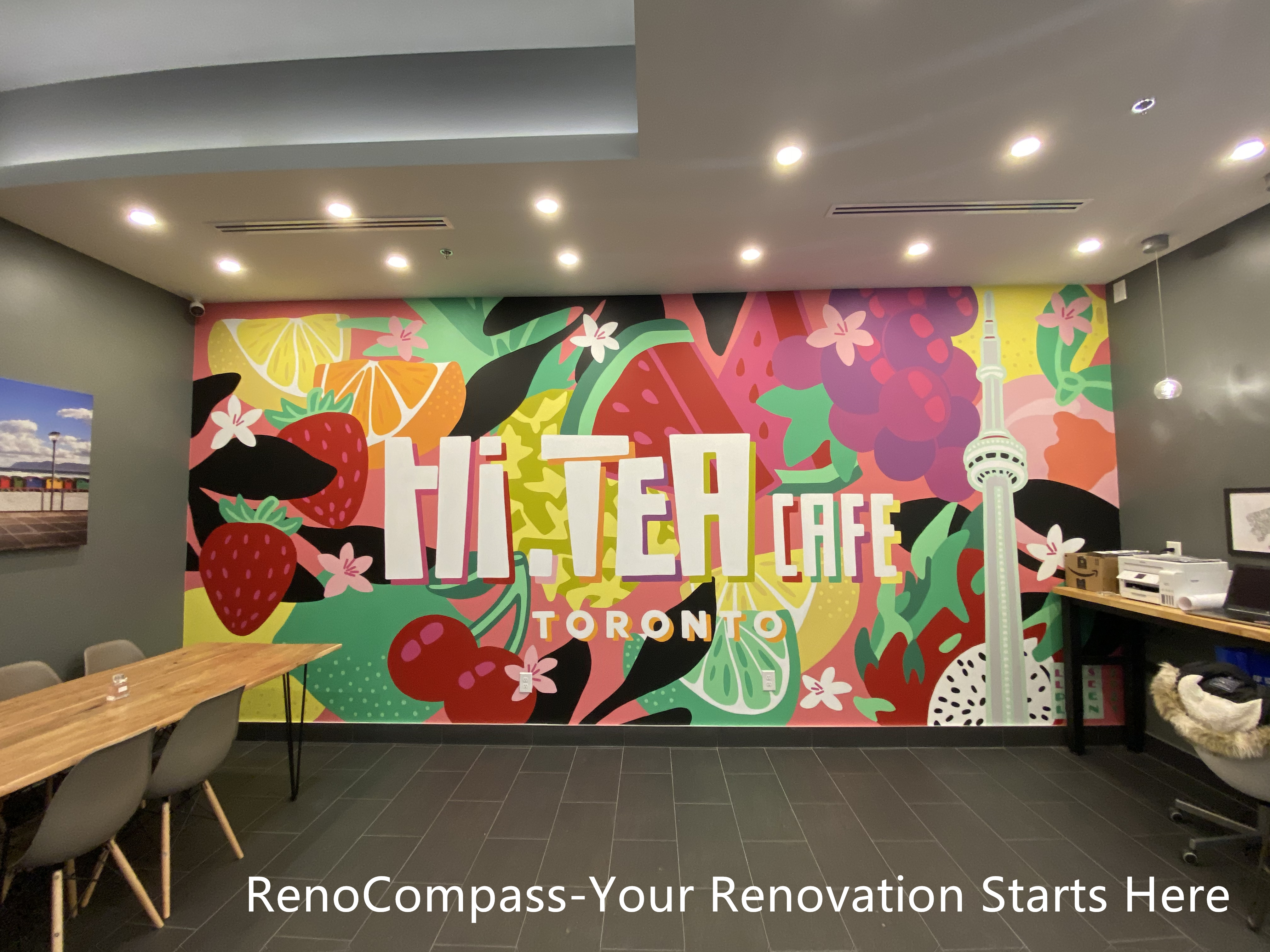Restaurant renovation project in Toronto highlighting a custom-designed feature wall mural, modern dining area layout, recessed ceiling lighting, and durable tiled flooring. This commercial interior by Reno Compass Inc. blends brand identity with functional seating design, creating a vibrant and welcoming atmosphere for customers.