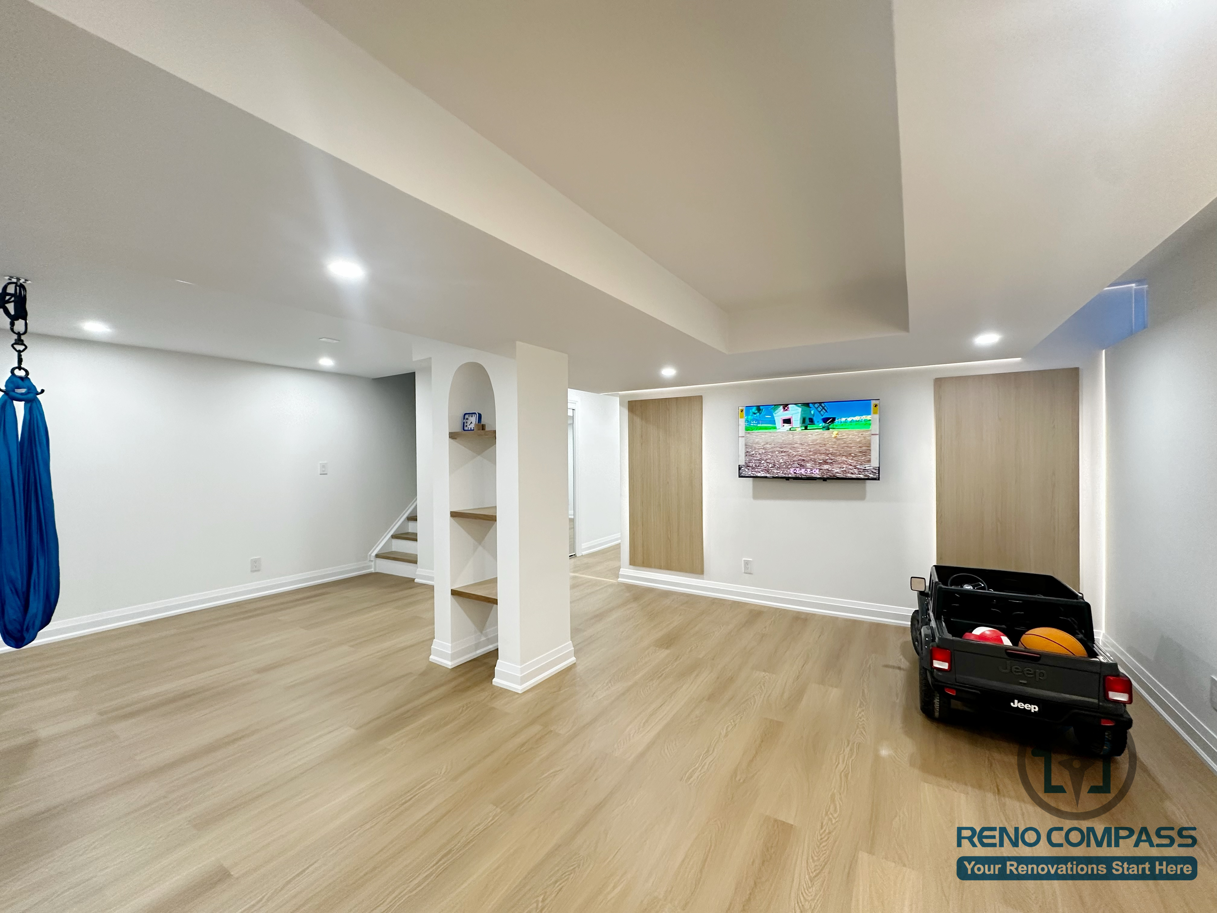 Spacious open-concept basement renovation in Markham featuring custom built-in shelving, recessed lighting, and light wood flooring. The layout supports recreation, play, and future multipurpose use while maintaining a clean, well-structured interior.