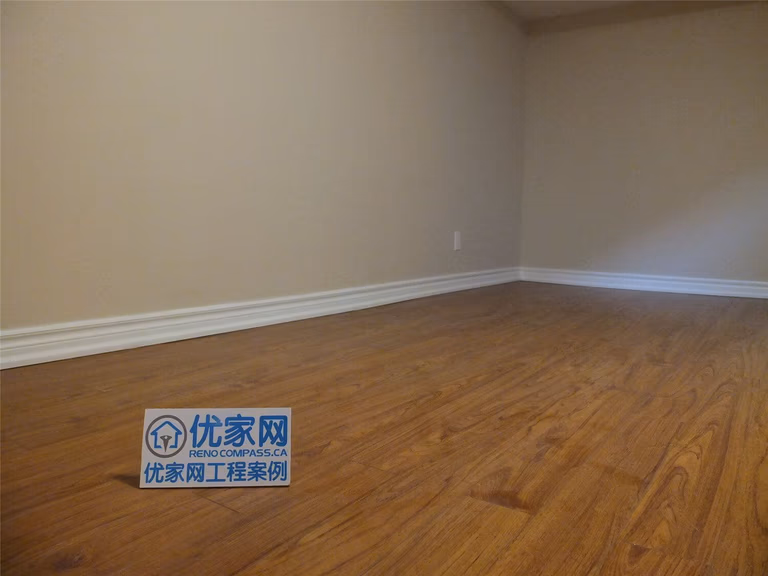 This Markham basement renovation project features newly finished walls, fresh interior painting, and durable laminate flooring installation. The clean wall finish, neutral paint tones, and wood-style flooring create a bright, comfortable living space suitable for a family recreation room or additional living area. Careful detailing around the baseboards and wall edges ensures a smooth and polished appearance throughout the basement interior.