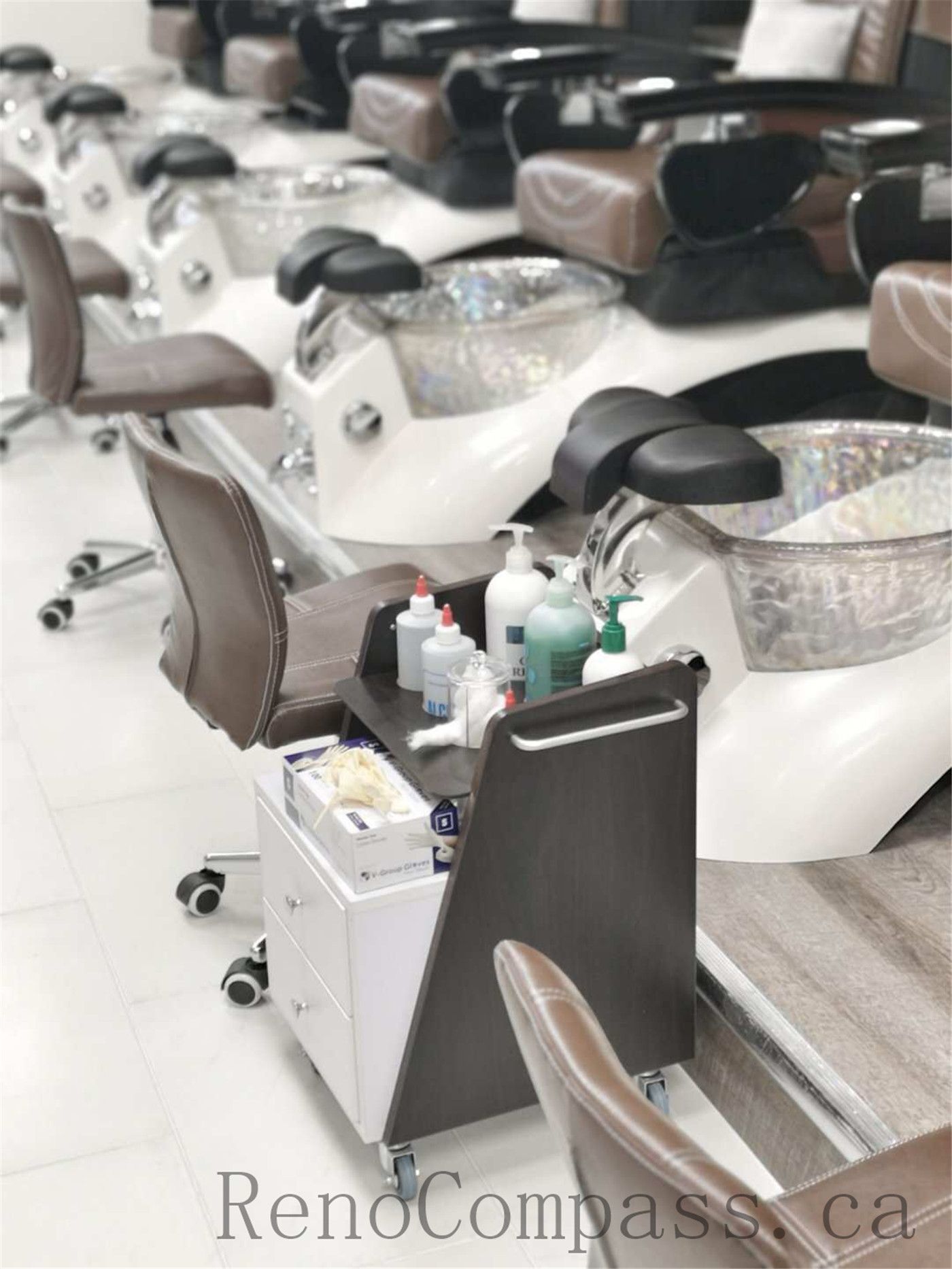 Toronto nail spa commercial renovation featuring a clean and welcoming reception counter, modern cabinetry, and a bright pedicure area with ergonomic client seating and integrated spa basins. The upgraded salon interior emphasizes hygiene, comfort, and efficient layout planning to enhance daily operations. Commercial beauty salon renovation completed by Reno Compass Inc., a professional Toronto renovation company specializing in nail spa and retail spaces.