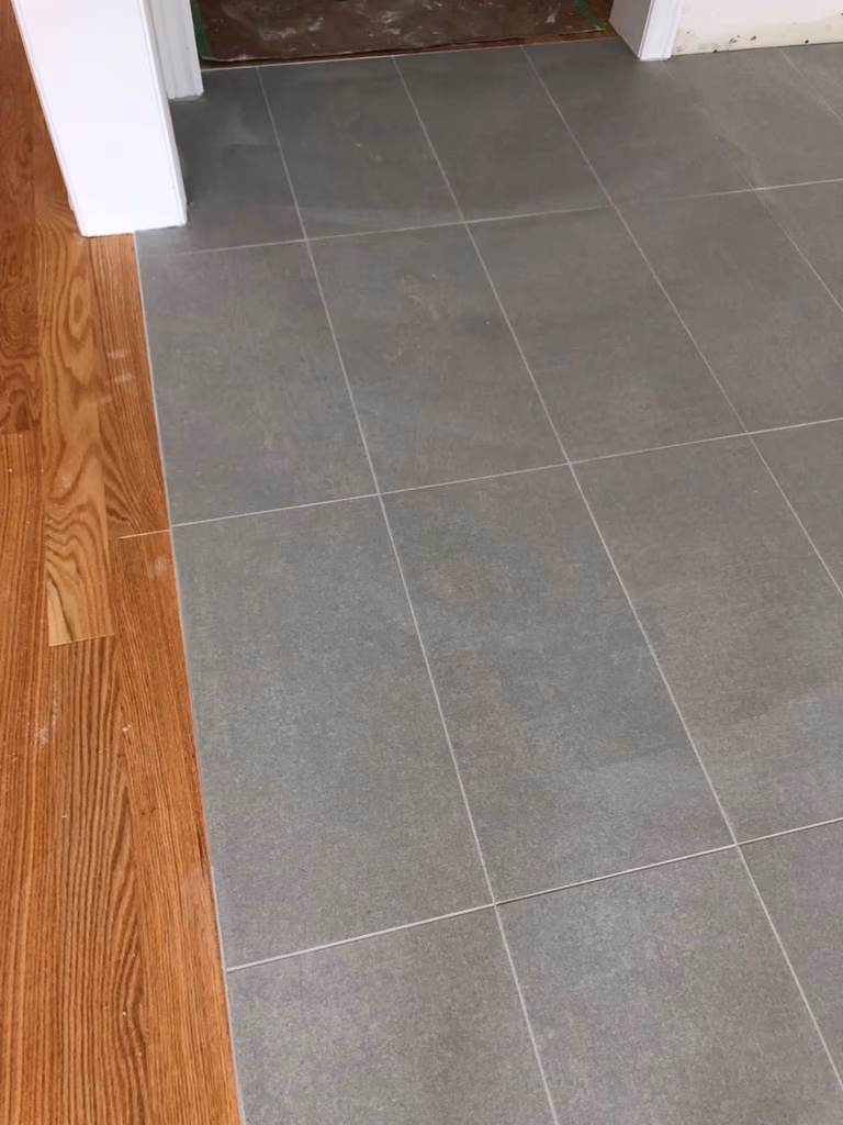 Large-format tile flooring installation in a Toronto interior renovation project. Clean tile alignment, consistent grout lines, and precise layout preparation help create a modern, durable, and easy-maintenance living space for everyday use.