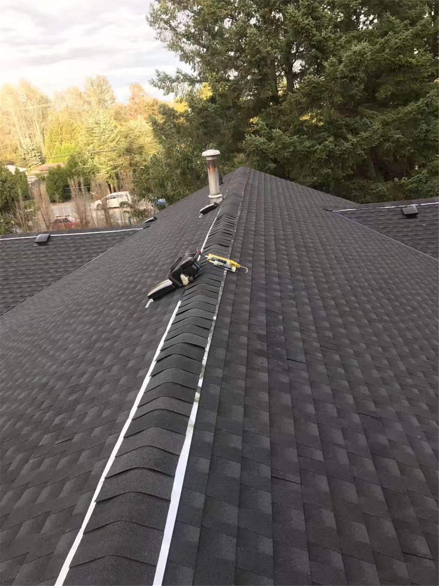 New asphalt shingle roof installation in Toronto, showing precise shingle alignment, proper underlayment coverage, and clean roof edge detailing. The roofing system includes upgraded flashing and vent pipe installation to ensure effective water drainage, ventilation, and long-term weather resistance. This roof replacement improves both durability and curb appeal while meeting Toronto building code standards.