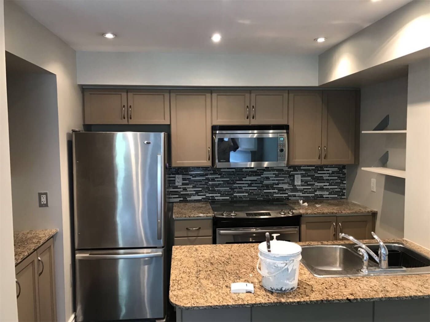 This image showcases a completed kitchen wall painting and interior refresh project in Toronto. The modern kitchen features freshly painted walls, updated cabinetry, granite countertops, and stainless steel appliances for a clean and contemporary look. Careful color selection and professional finishing enhance brightness and visual harmony throughout the space. Completed by an experienced Toronto renovation and painting team, this project highlights high-quality workmanship, smooth wall finishes, and detailed interior improvements designed to elevate everyday living and long-term property value.