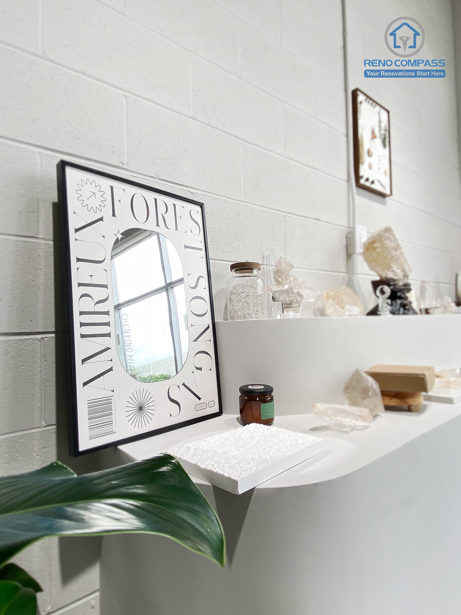 This image highlights a minimalist display shelf detail from a crystal shop renovation in Markham. The floating white shelf is set against a painted masonry wall, showcasing curated crystals, decorative objects, and framed artwork. Clean lines, subtle textures, and thoughtful styling create a calm, gallery-inspired retail atmosphere. As a Toronto renovation company, Reno Compass specializes in boutique retail renovations that emphasize material quality, display design, and refined finishing details.