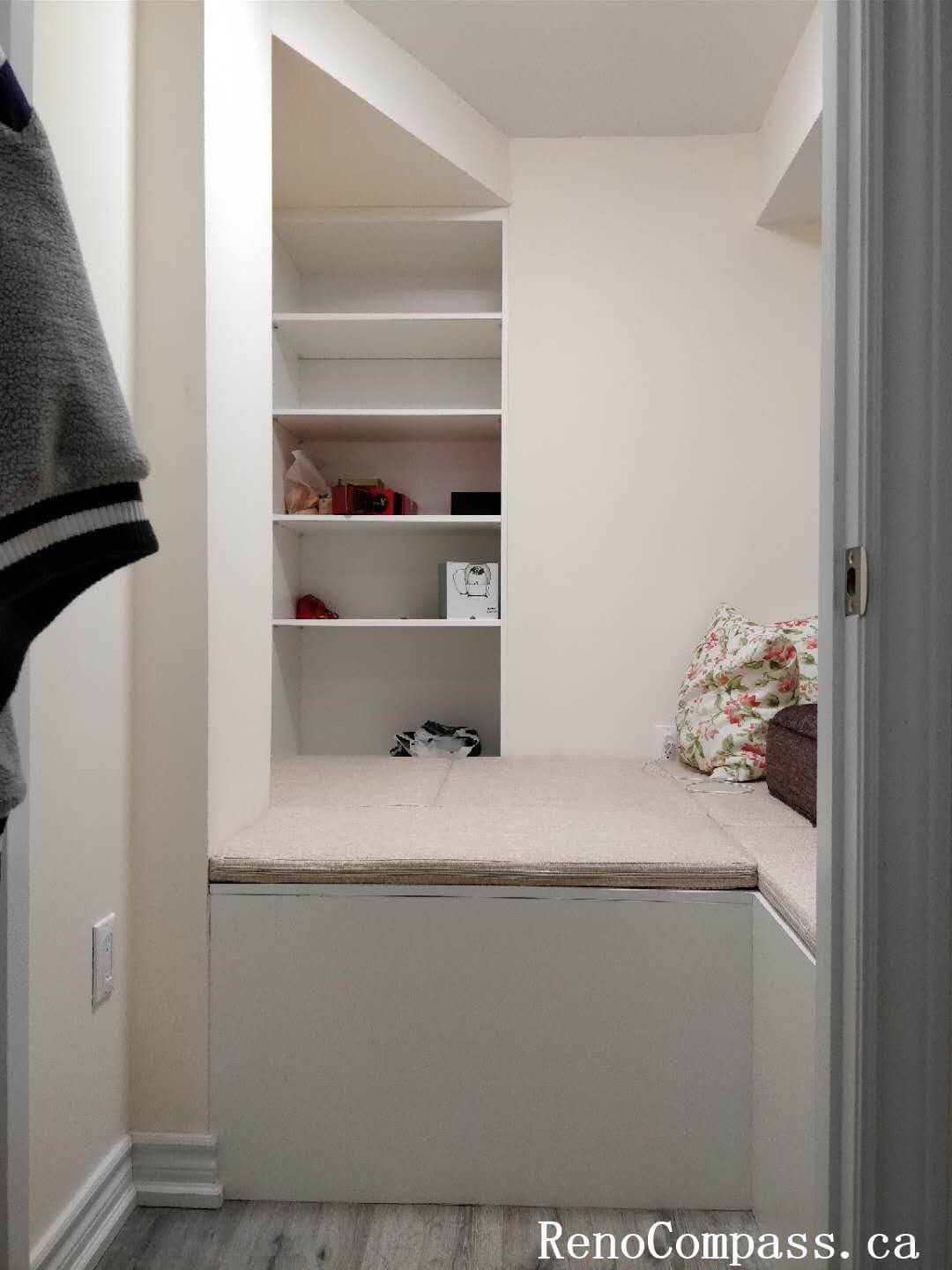 A high-quality custom mudroom renovation in Markham featuring white shaker-style lower cabinets, a built-in seating bench, open cubby shelving, and an integrated garment hanging rod for maximum organization.