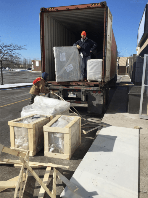 This image captures the equipment delivery phase of a 7000 sqft private club renovation project in Toronto. Large commercial fixtures and custom-built components are being unloaded from a shipping container, carefully prepared for interior installation.

The project involves coordinated logistics, material handling, and staged installation to ensure smooth construction progress. Deliveries like these typically include custom furniture, structural components, or entertainment-related equipment required for a high-end private club build-out.

Managed by an experienced Toronto renovation team, this large-scale commercial project demonstrates organized project planning, safe material handling, and professional construction workflow from delivery to final installation.

该图片展示多伦多7000尺私人俱乐部装修项目的设备到场阶段，大型商业设施与定制部件正在从集装箱中卸货，为后续室内安装做准备。

项目涉及物流协调、材料管理及分阶段安装安排，确保工程顺利推进。由专业多伦多装修团队统筹管理，体现大型商业装修项目从材料进场到施工安装的规范流程与专业度。