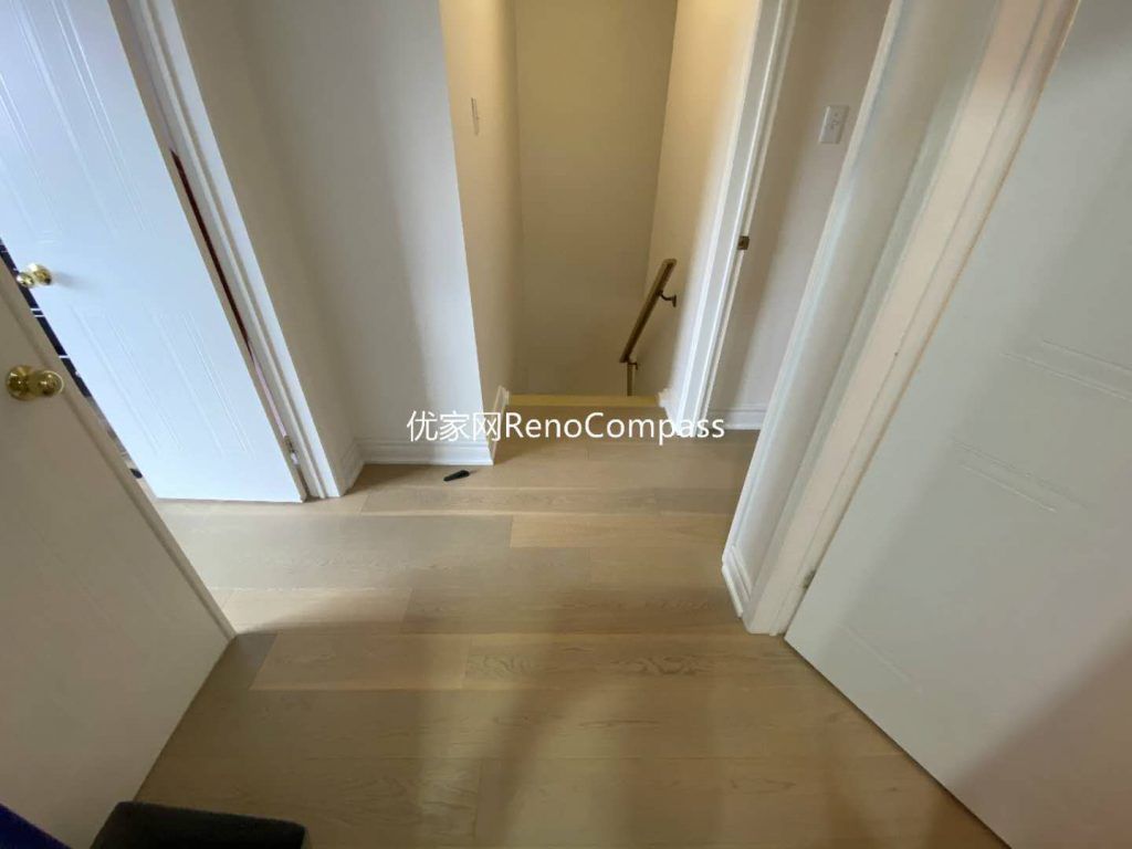 This image highlights a completed interior renovation in Mississauga, focusing on upgraded hallway flooring and improved staircase access. Light-toned engineered wood flooring creates a seamless visual transition between rooms, enhancing brightness and spatial continuity. Clean wall finishes, precise trim detailing, and safe stair handrail installation contribute to a practical and well-organized circulation area. The renovation prioritizes durability, safety, and everyday comfort, reflecting the thoughtful planning and execution of a professional Toronto renovation company.