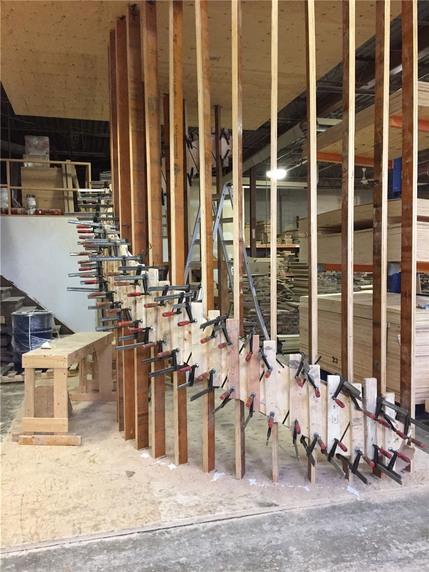This image shows the structural framing stage of a custom curved staircase being built for a Toronto stair renovation project. Vertical wood supports and multiple clamps are used to carefully shape and secure the curved stair structure, ensuring precise alignment and long-term strength. This step highlights the craftsmanship required to construct complex staircase designs before final finishing and installation. As an experienced Toronto Renovation Company, Reno Compass Inc. specializes in custom staircase fabrication and renovation, delivering durable and visually striking stair solutions for homes throughout Toronto and the Greater Toronto Area.