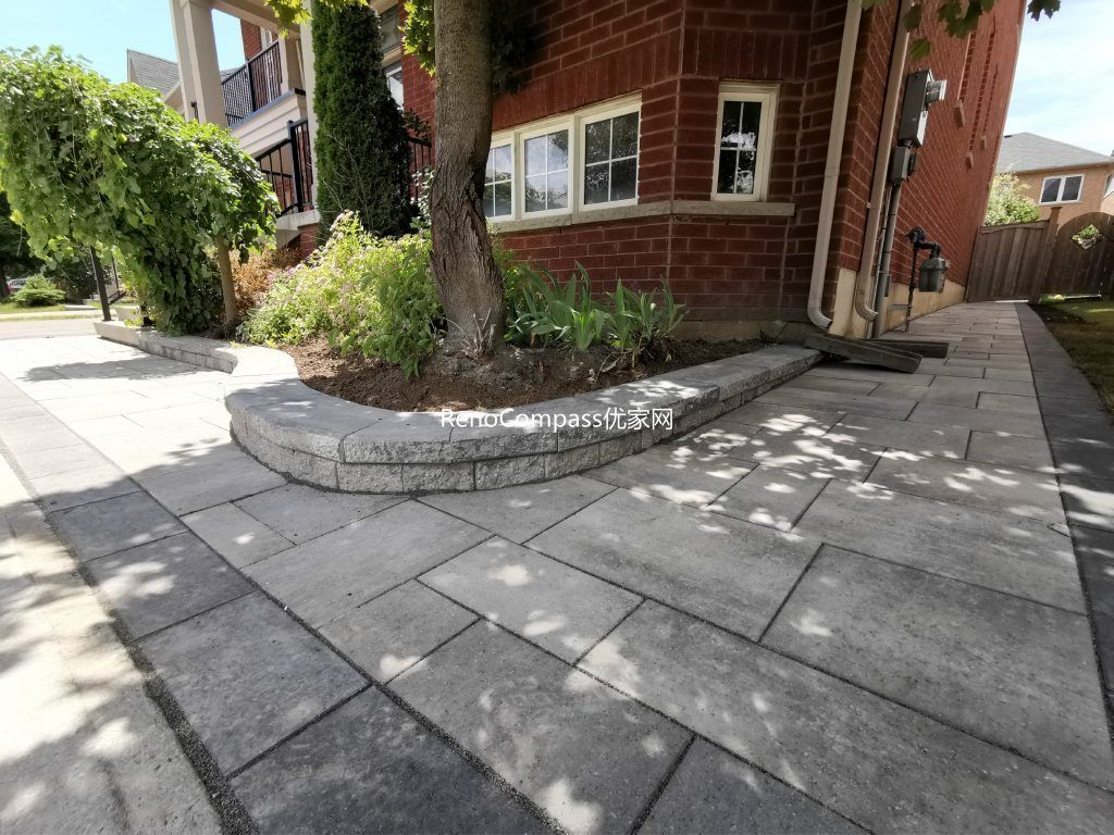 Side walkway installation in Richmond Hill with interlocking gray stones and a raised garden edge. This clean, contemporary design complements the home’s landscape while improving functionality and drainage.