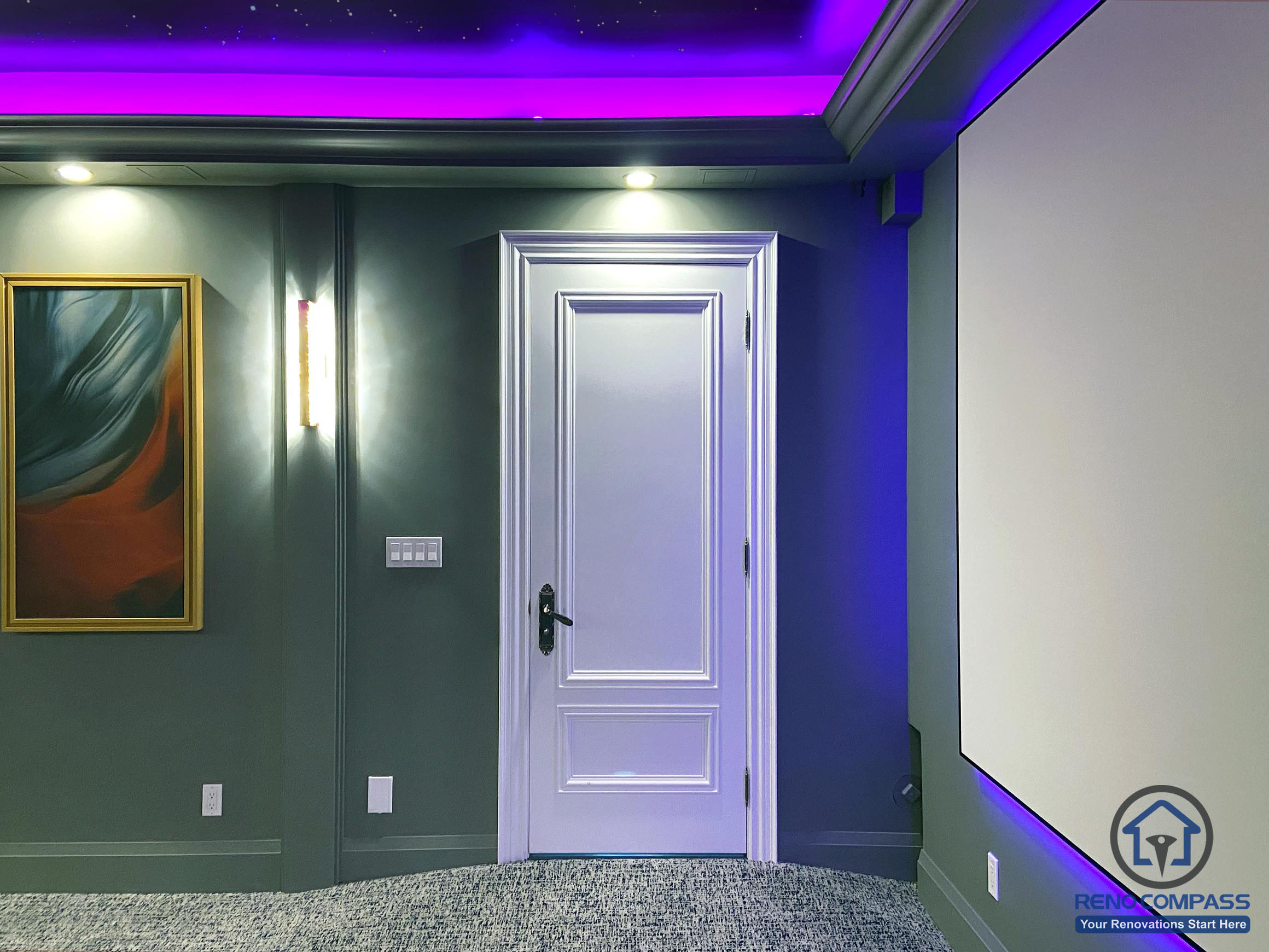 Entry area of a home theatre renovation in Aurora featuring a custom interior door, wall lighting, and ambient LED accents integrated into the cinema space.