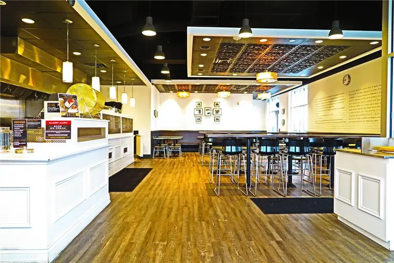 This completed Toronto restaurant renovation project showcases the finished dining area and full commercial interior upgrade by Reno Compass Inc. The space features modern wood-look commercial flooring, custom-built service counters, high-top seating arrangements, and integrated lighting systems designed to create a warm and inviting atmosphere.

The layout maximizes seating capacity while maintaining clear circulation pathways for both customers and staff. Decorative ceiling elements and wall-mounted design features enhance visual character while preserving a clean and professional commercial standard.

As a trusted Toronto renovation company, Reno Compass Inc. specializes in full restaurant interior renovations that improve operational efficiency, visual appeal, and long-term durability for food service businesses across the GTA.