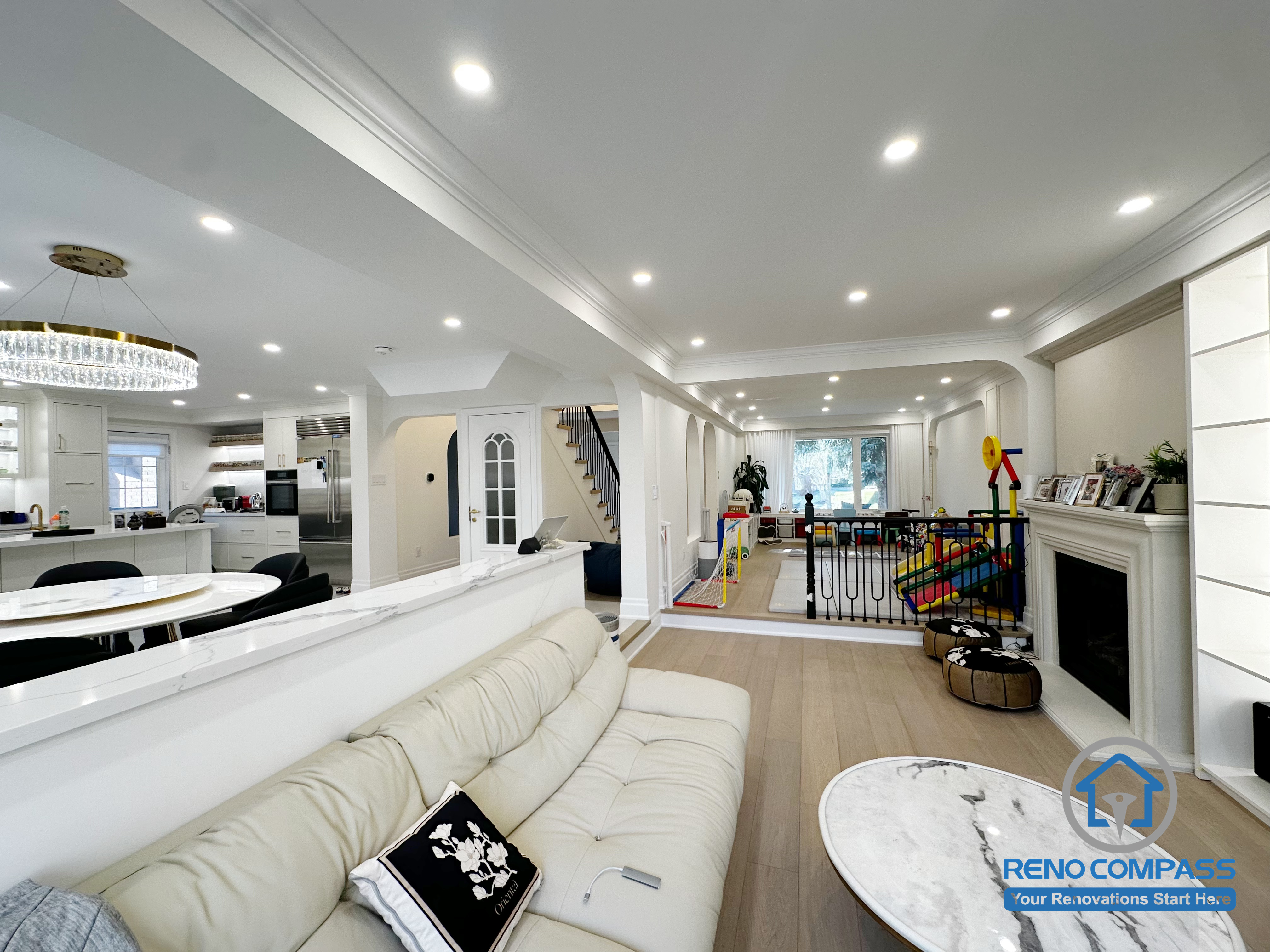 This Markham interior renovation reimagines the main living area as a bright, open-concept space that seamlessly connects lounging, dining, and family activity zones. The layout is designed to enhance visual continuity while maintaining comfortable separation between different functions of the home.

A half-height partition helps define the living room without blocking sightlines, allowing natural light to flow through the space. Recessed ceiling lighting and consistent architectural details create a clean, cohesive look throughout the interior. The open connection to the kitchen and family areas supports everyday interaction and makes the space ideal for both relaxation and entertaining.

By focusing on layout balance, lighting design, and long-term usability, this renovation delivers a refined yet practical interior environment suited for modern family living in Markham.