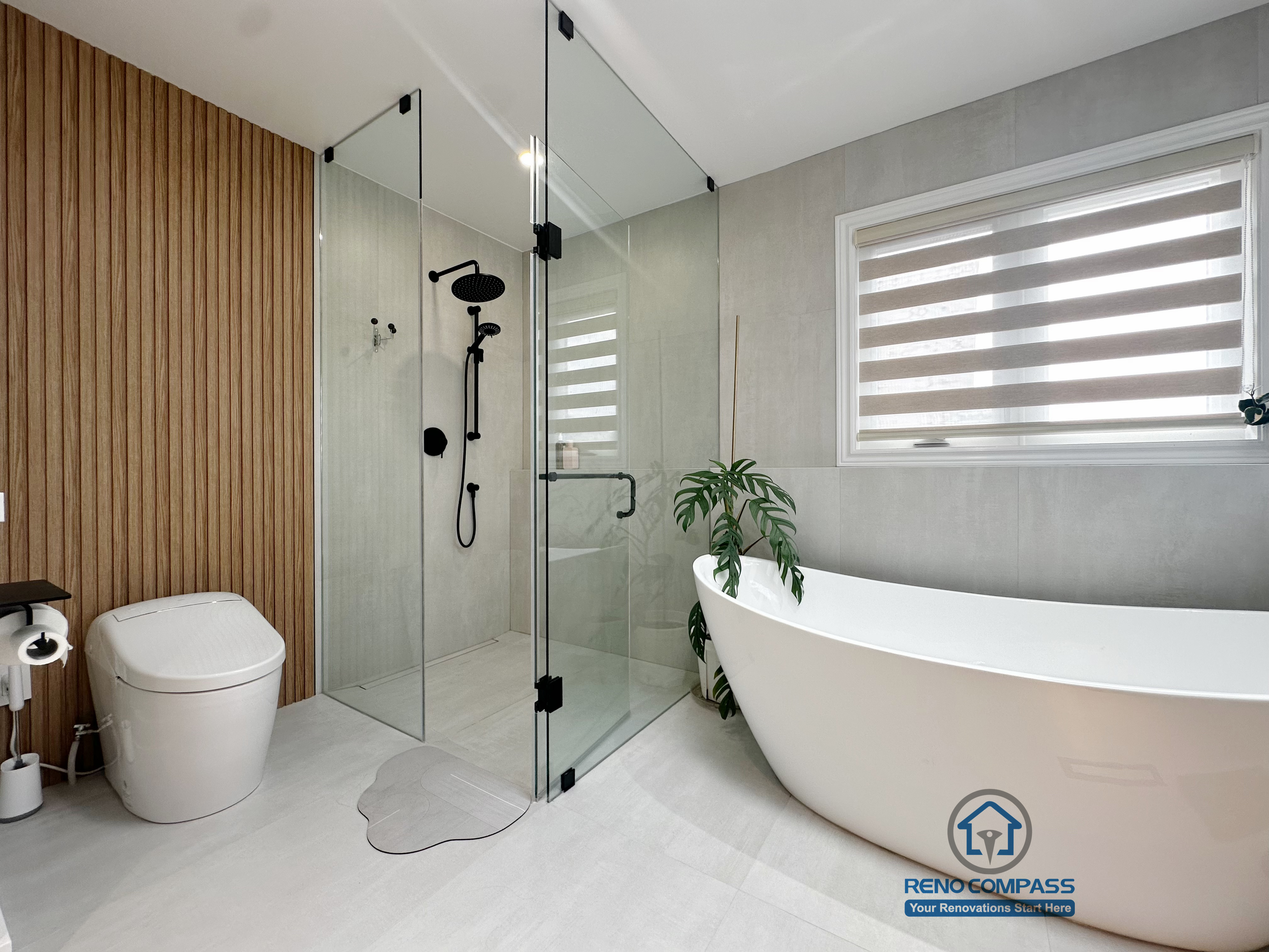 A modern curbless bathroom renovation by Reno Compass in Markham, Toronto.
This layout features a frameless glass shower, freestanding bathtub, and warm vertical wood accents that balance functionality, privacy, and visual openness.