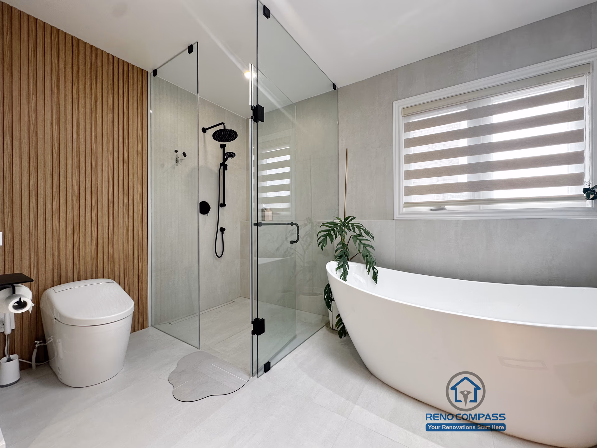 A modern curbless bathroom renovation by Reno Compass in Markham, Toronto.
This layout features a frameless glass shower, freestanding bathtub, and warm vertical wood accents that balance functionality, privacy, and visual openness.