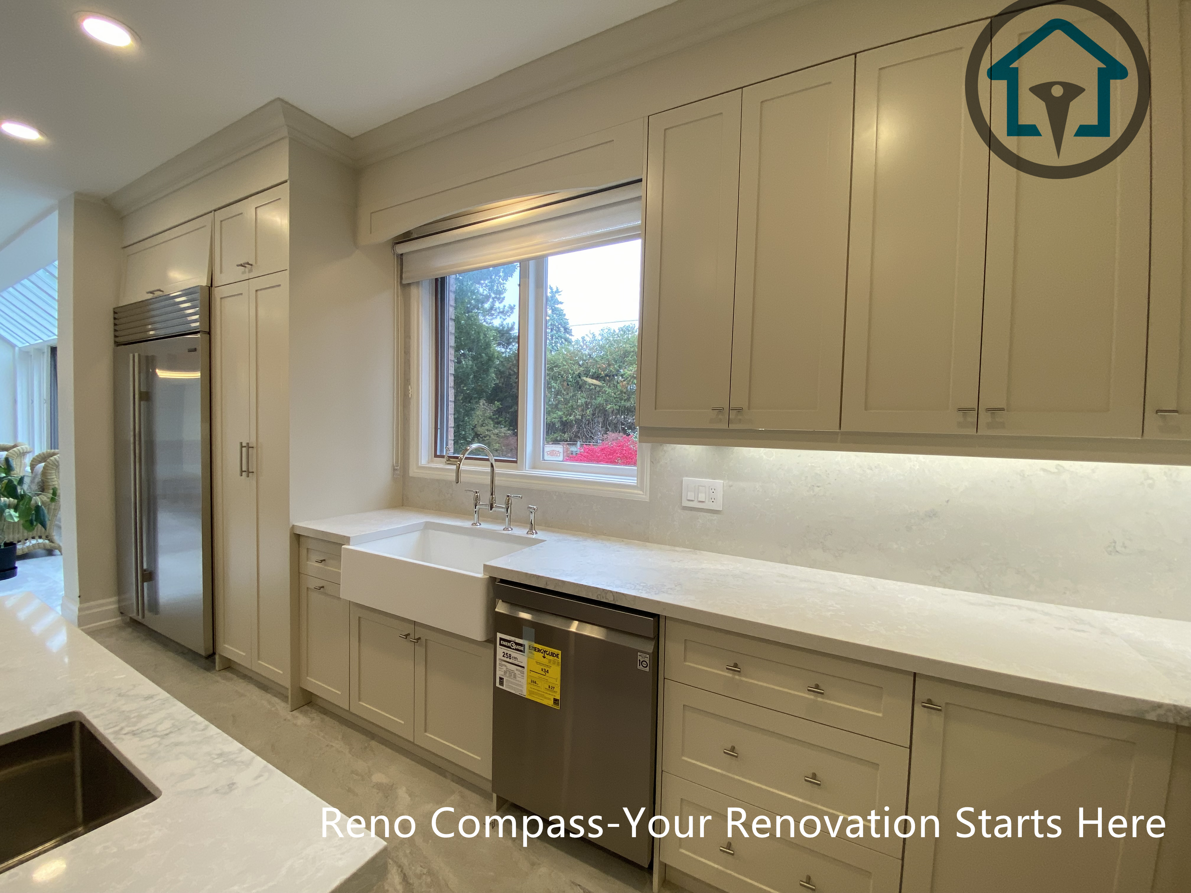 This kitchen renovation highlights a custom sink wall with built-in cabinetry, integrated lighting, and a clean countertop layout designed for daily efficiency. Natural light from the window enhances the workspace as part of a Thornhill home renovation completed by Reno Compass.