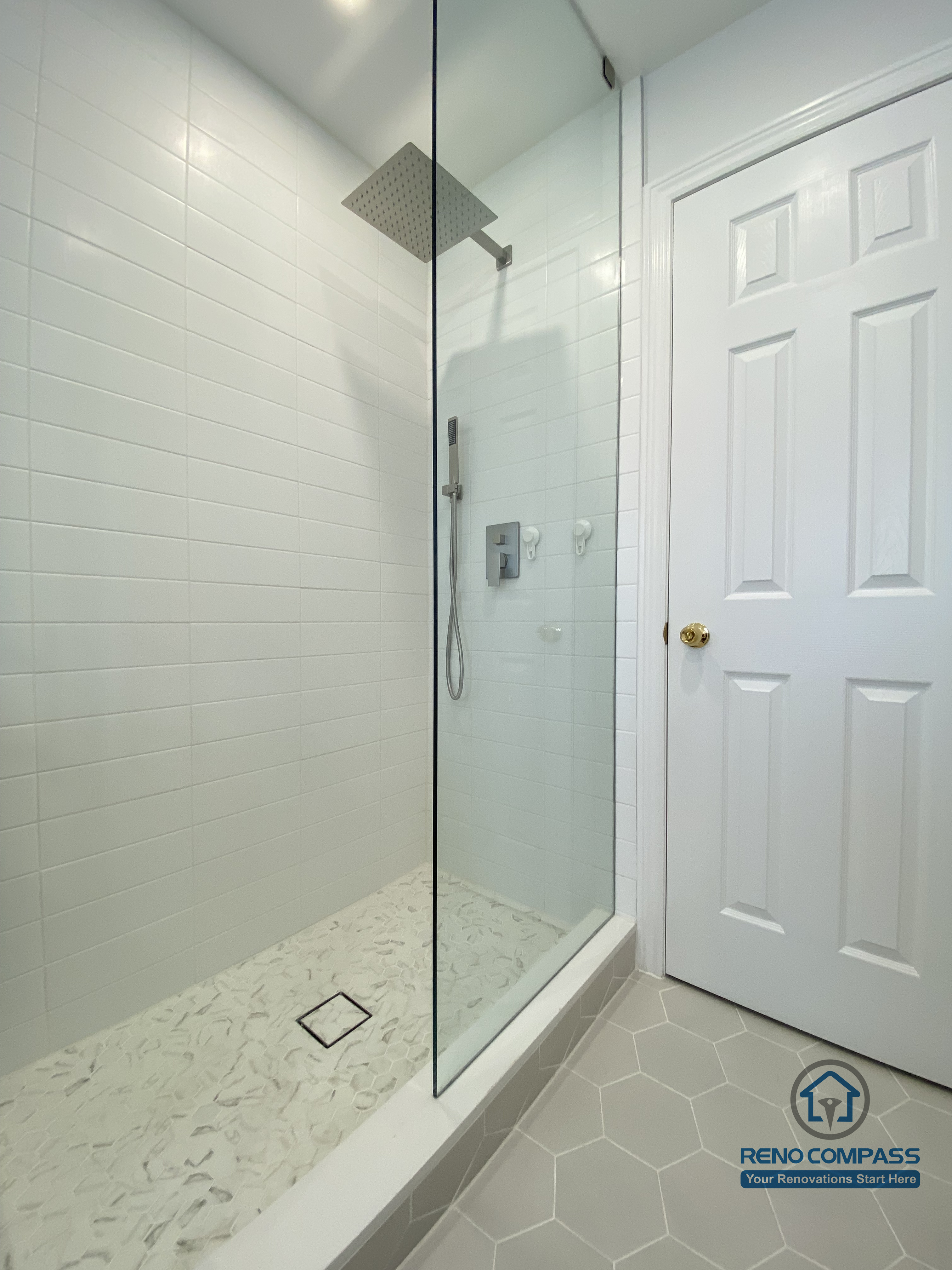 This Markham bathroom renovation features a frameless glass shower enclosure with a rainfall shower head, white subway wall tiles, and a custom tiled shower base. The clean lines and moisture-resistant materials create a modern, easy-to-maintain shower space, completed by an experienced Toronto renovation company.