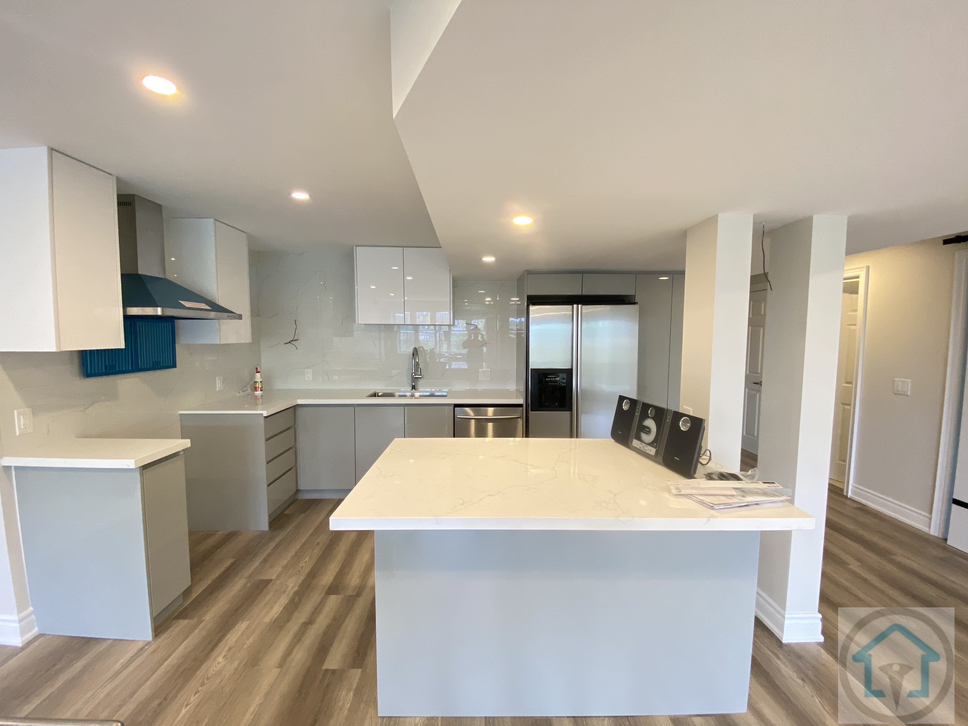 This Newmarket basement renovation features a modern open-concept kitchen with a central island, sleek cabinetry, and integrated appliances. Recessed lighting and a clean layout enhance functionality and visual flow, making the basement kitchen suitable for daily use, entertaining, or extended family living.