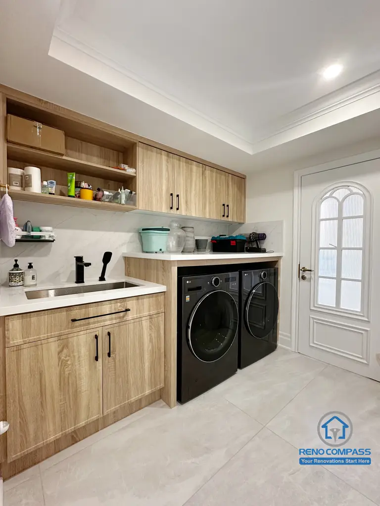 This custom laundry room was completed as part of a full interior renovation in Markham. The space was designed with practicality and durability in mind, featuring wood-grain cabinetry for concealed storage, open shelving for daily essentials, and an integrated countertop with utility sink. Front-loading washer and dryer units were built seamlessly into the layout to maintain a clean, organized appearance, while the neutral finishes and recessed lighting help keep the room bright and easy to maintain for everyday household use.